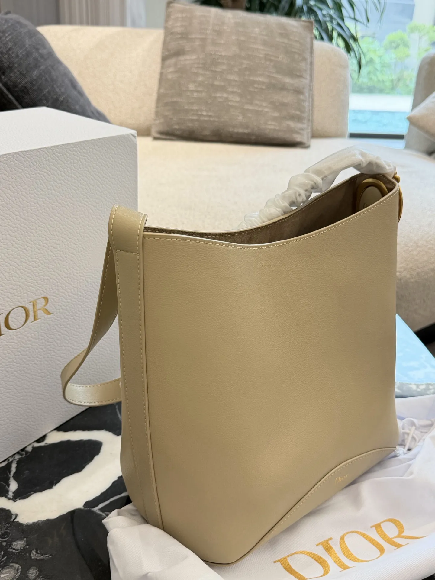 p250 Dior Diorbook手袋​​ 👜Dior Diorbook手袋采用优质小牛皮，触感细腻耐用，浅米色搭配白色褶皱肩带，简约优雅✨。弧形包身线条流畅，正面&ldquo;Dior&rdquo;标志低调精致。肩带可调节，支持手提或斜挎，日常通勤、休闲出行都很百搭。内部空间宽敞，手机、钱包、化妆品轻松收纳，实用又时髦，是Dior经典系列热门款！25&times;30