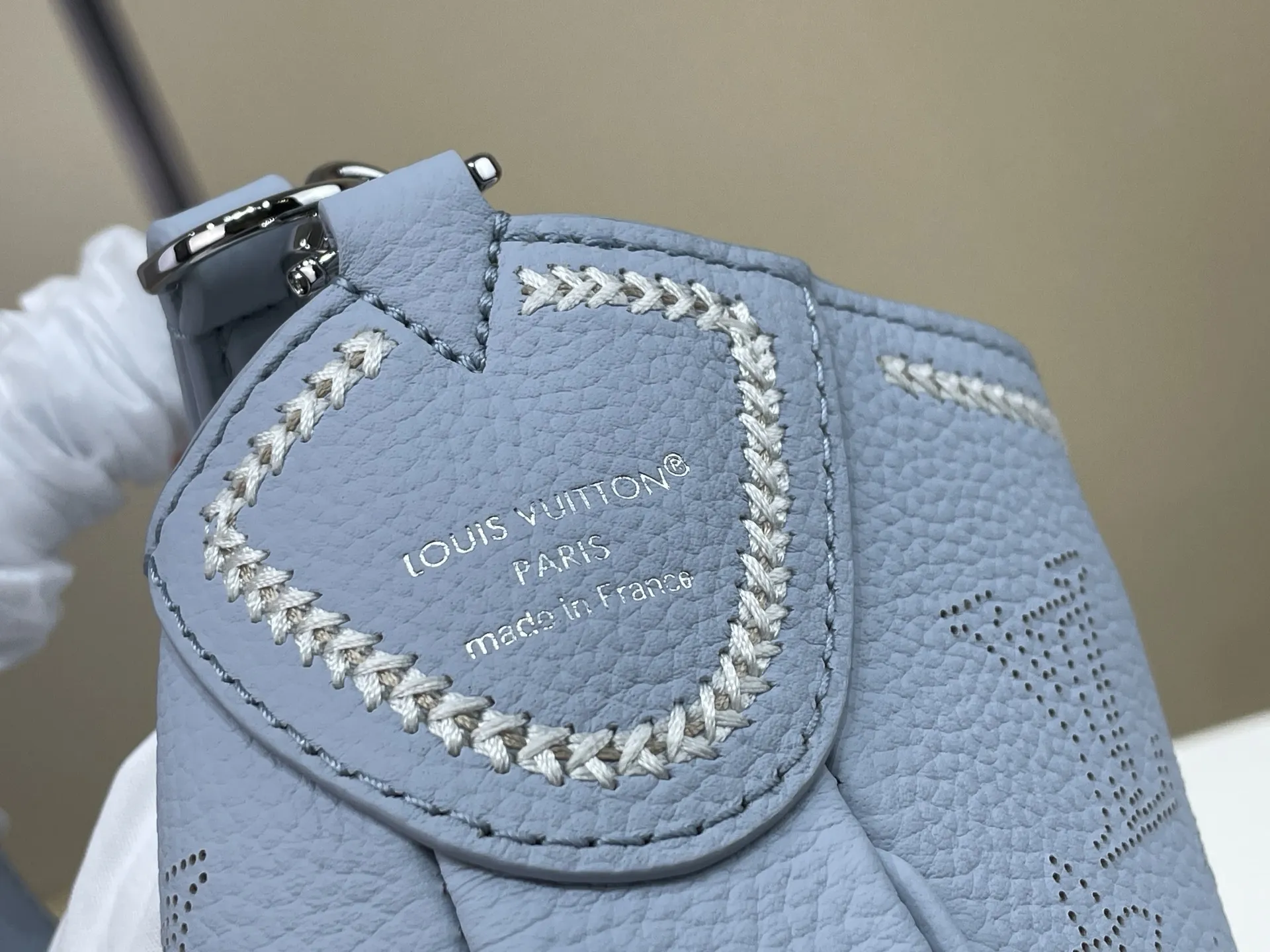 复刻独家实拍📷【ALL AROUND 小号手袋 】 m28779 蓝色（冲孔） Mahina Couture 系列以优雅色调重绎 All Around 小号手袋，再为牛皮革铺陈Monogram 穿孔图案，与编织纹理刺绣细节共筑色彩反差。标志性 LV 挂锁点睛考究构型，可调节肩带提供多种背携方式。 尺寸：25 x 20 x 6 厘米 (长度 x 高 x 宽)