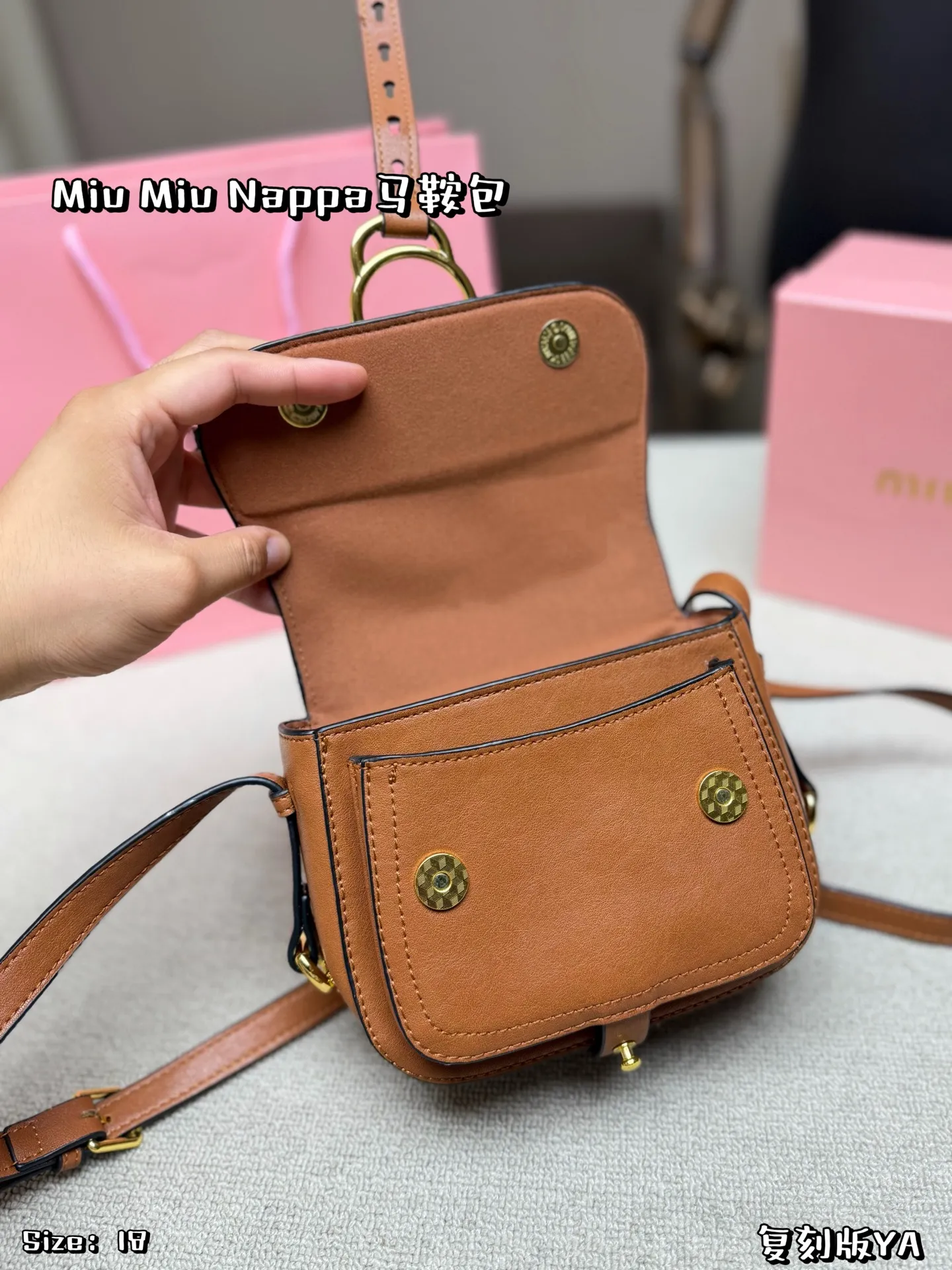 P180 配盒子 Miu Miu Nappa马鞍包，手感细腻又耐用。黑色包身配金属圆环，复古精致感满满✨。马鞍包型容量适中，日常通勤、休闲都能轻松驾驭。肩带可调节，斜挎or单肩都OK，实用又时髦！Nappa系列是Miu Miu经典，优雅又有个性，超适合喜欢时尚的姐妹们 尺寸 18*16