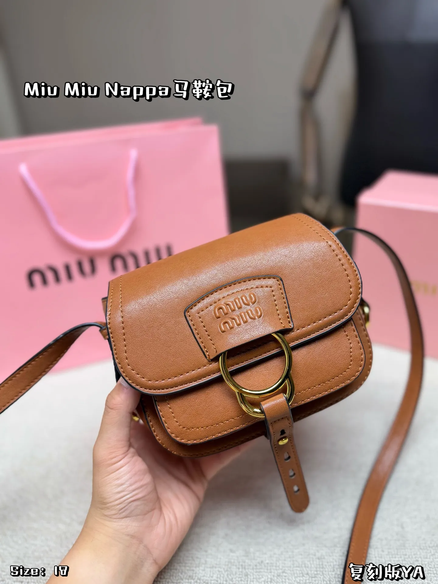 P180 配盒子 Miu Miu Nappa马鞍包，手感细腻又耐用。黑色包身配金属圆环，复古精致感满满✨。马鞍包型容量适中，日常通勤、休闲都能轻松驾驭。肩带可调节，斜挎or单肩都OK，实用又时髦！Nappa系列是Miu Miu经典，优雅又有个性，超适合喜欢时尚的姐妹们 尺寸 18*16