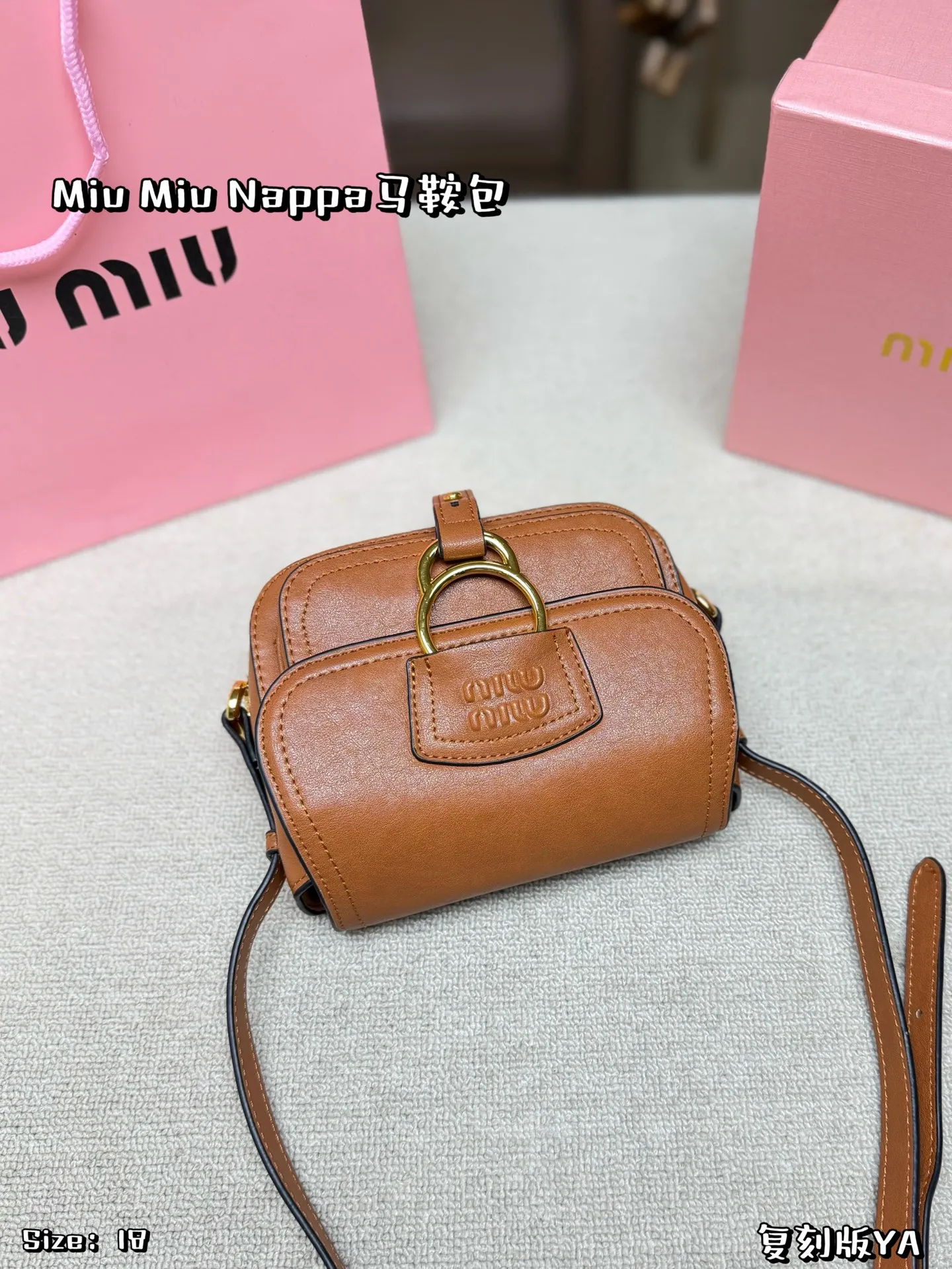 P180 配盒子 Miu Miu Nappa马鞍包，手感细腻又耐用。黑色包身配金属圆环，复古精致感满满✨。马鞍包型容量适中，日常通勤、休闲都能轻松驾驭。肩带可调节，斜挎or单肩都OK，实用又时髦！Nappa系列是Miu Miu经典，优雅又有个性，超适合喜欢时尚的姐妹们 尺寸 18*16