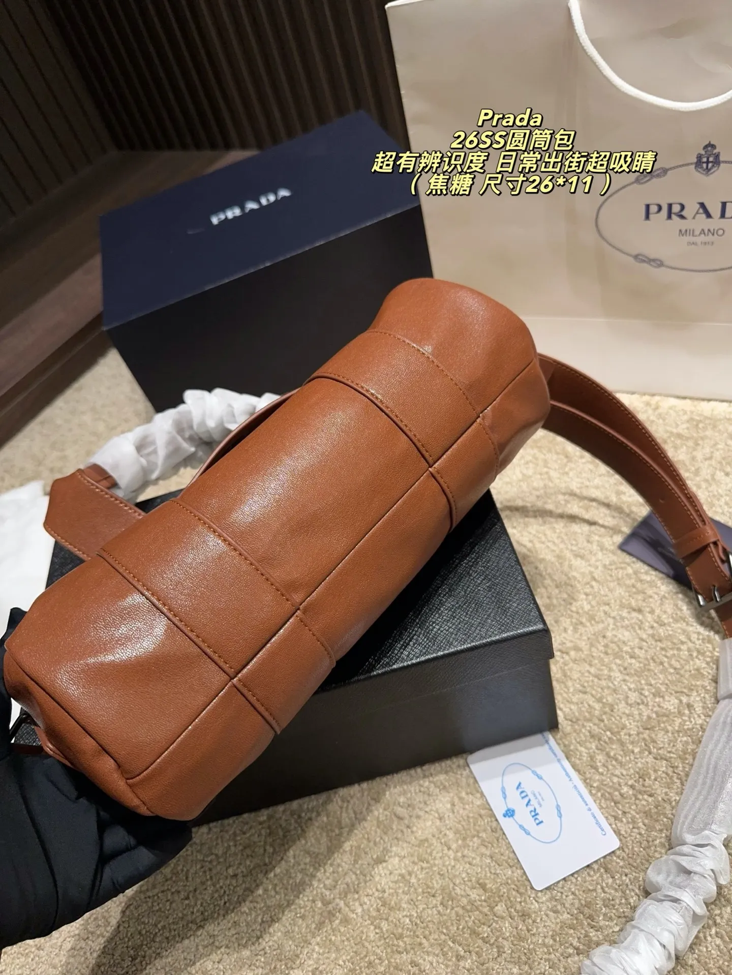p180配盒⚠️尺寸26*11 普拉达Prada 26SS圆筒包是2023春夏系列快闪限定,棕色皮革+金属孔眼,简约又有工业感✨。圆筒造型容量适中,通勤休闲都OK!肩带可调节,手提斜挎随心切换,实用性满分。无性别设计,男女都能轻松驾驭,时尚又百搭,超适合喜欢个性风格的你!