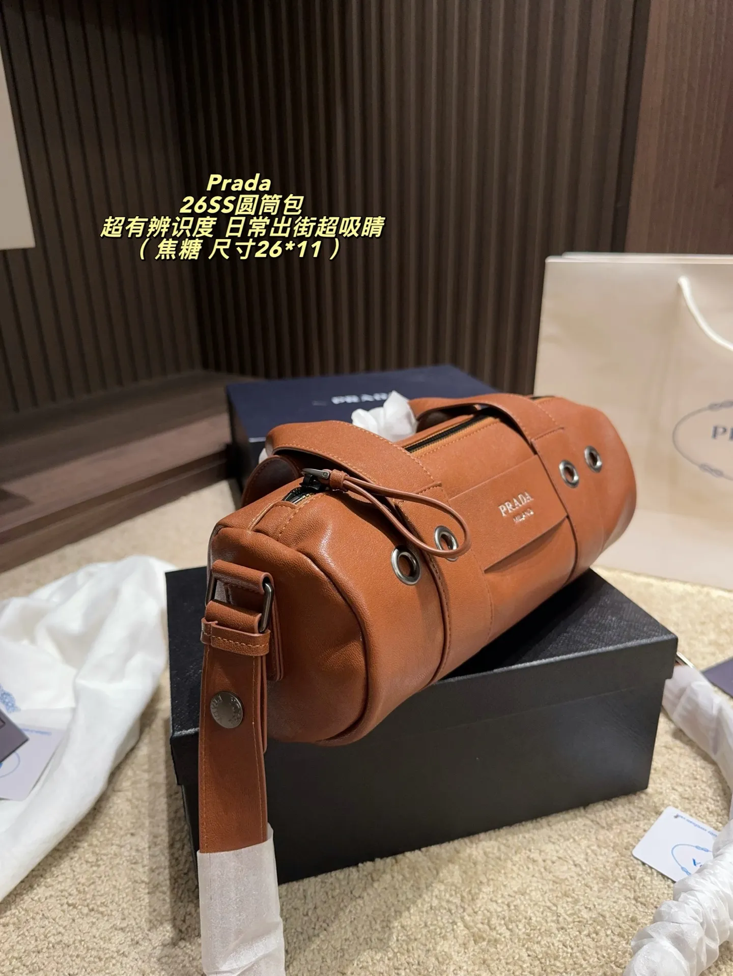 p180配盒⚠️尺寸26*11 普拉达Prada 26SS圆筒包是2023春夏系列快闪限定,棕色皮革+金属孔眼,简约又有工业感✨。圆筒造型容量适中,通勤休闲都OK!肩带可调节,手提斜挎随心切换,实用性满分。无性别设计,男女都能轻松驾驭,时尚又百搭,超适合喜欢个性风格的你!