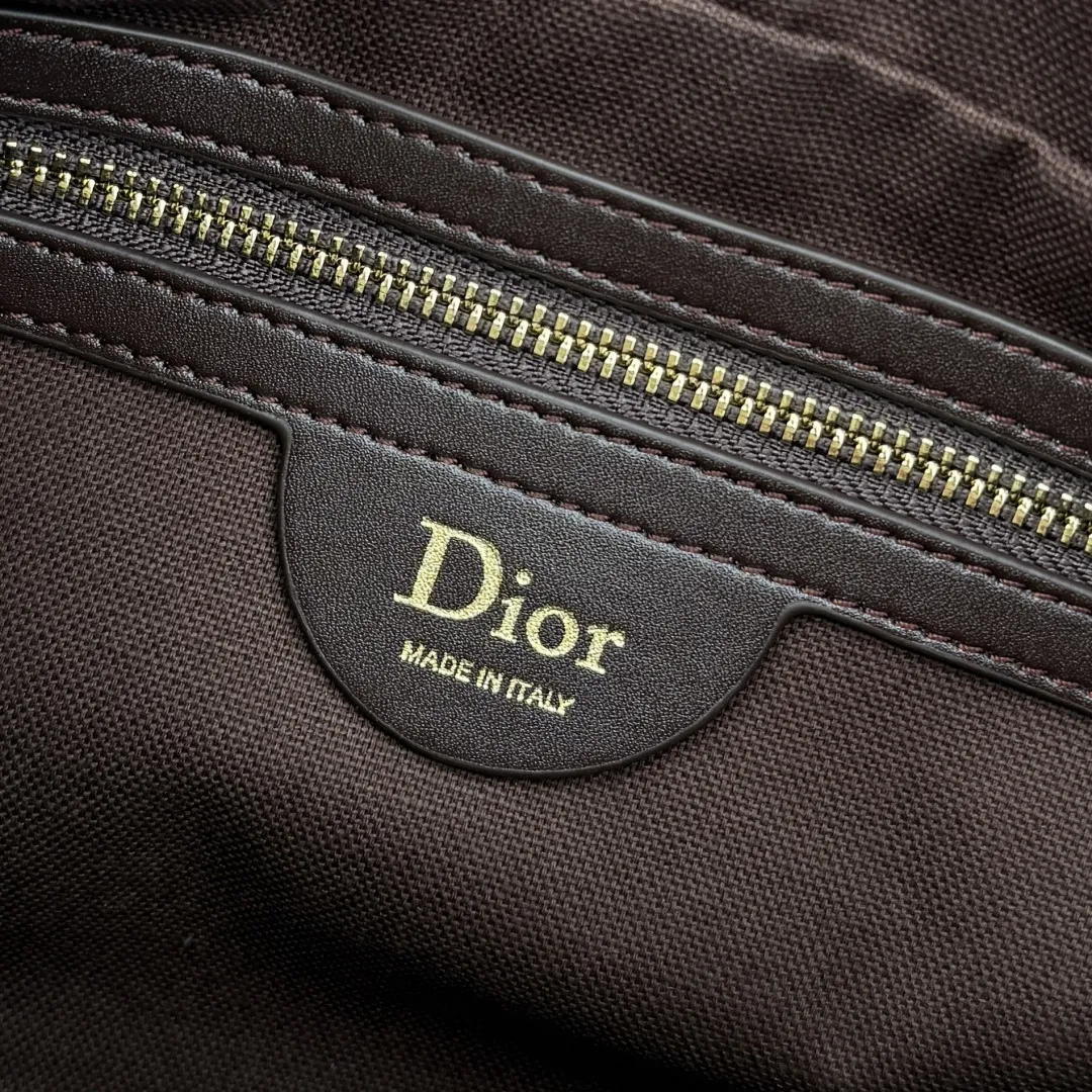 【编号: M1441】咖啡色 这款 Dior Granville 手袋由乔纳森·安德森 (Jonathan Anderson) 为 Dior 倾情呈献,以时髦的廓形重新诠释 Dior 的经典标识。日常配饰,将实用功能与雅致风格巧妙融合,可手提、肩背或斜挎。 主体:牛皮革,羊皮革 里料:棉,亚麻,羊皮革 双向拉链开合 可拆卸的 D.I.O.R. 吊饰 皮革手柄 可调节、可拆卸的皮革肩带 内部拉链口袋 垫脚 内含防尘袋 意大利制造 编号: M1441 尺寸:25 x 16.5 x 14.5 厘米(长 x 高 x 宽)