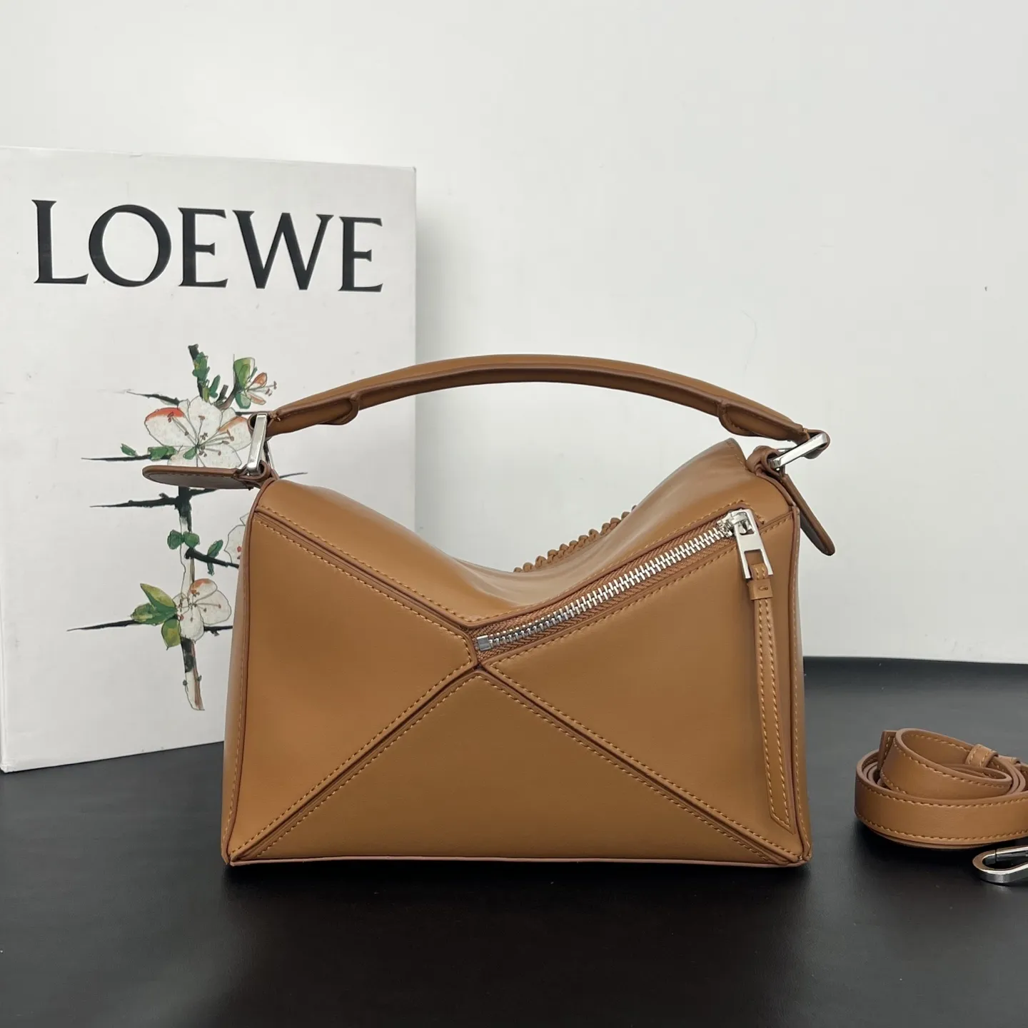 💰310 Loewe puzzle 新品 头层牛皮 流苏几何包 几何包型上的飘逸&ldquo;马鬃&rdquo; 今年的Puzzle，最妙的是包身上同色调的流苏装饰，就像骏马奔跑时飞扬的鬃毛，瞬间打破了Puzzle标志性几何拼接的冷静感，多了一份灵动和潇洒。黑白双色取自骏马灵感，更添一分别样的松弛和洒脱。尺寸 24&times;10.5&times;16.5cm 款号：193