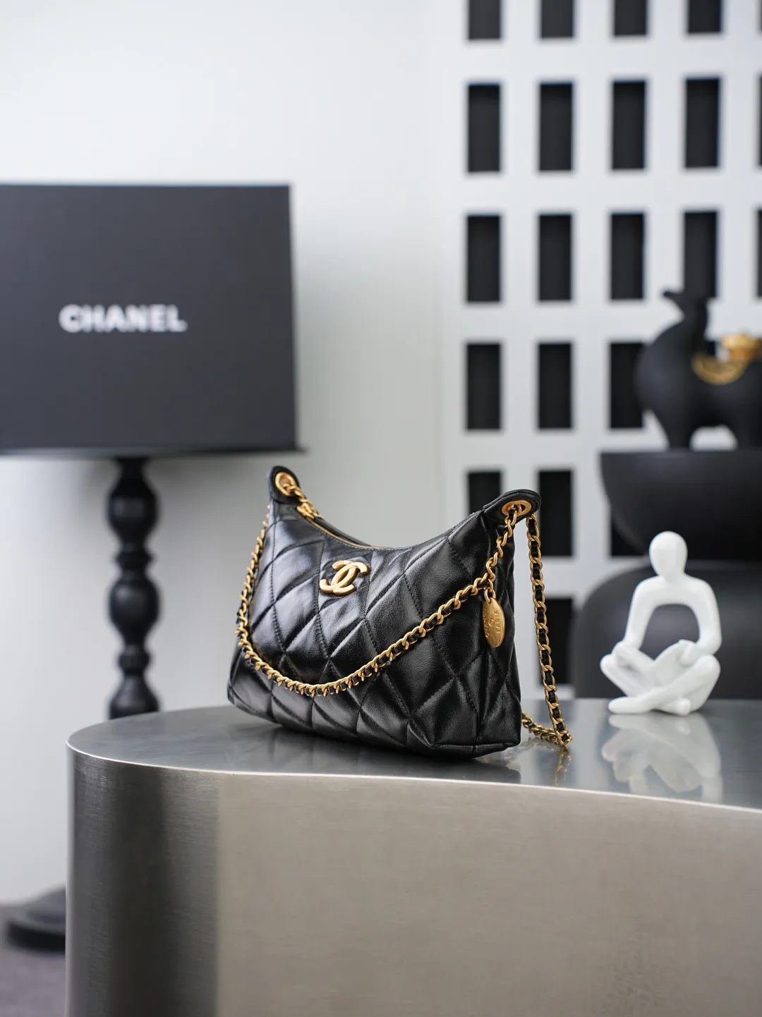 💼𝑪𝒉𝒂𝒏𝒆𝒍 𝟐𝟓𝑺 | 腋下包𝒉𝒐𝒃𝒐👜 💜独家背景💜实物实拍/顶级质量 ✨细腻饱满的黑色小羊皮🖤，触感柔软顺滑，菱格绗缝走线工整利落，自带低调复古氛围。搭配穿皮金属链条，解锁腋下、单肩多种背法。内里为同色系衬里，搭配烫金标识，分层隔袋设计，轻松容纳日常随身物品。哑光金五金温润高级，整体兼具实用与格调💫，是日常通勤的百搭单品。 款号：𝑨𝑺 𝟓𝟓𝟐𝟖黑色羊皮 尺寸：𝟏𝟕*𝟐𝟔*𝟖.𝟓𝒄𝒎/带包装盒