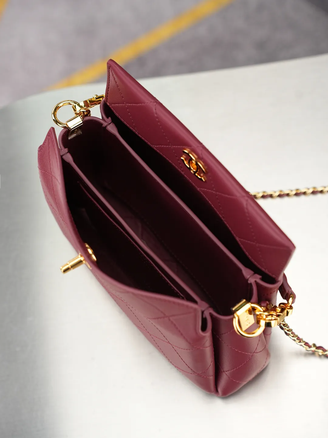 💼𝑪𝒉𝒂𝒏𝒆𝒍 𝟐𝟔𝑺 | 手提𝒉𝒐𝒃𝒐口盖包👜 💜独家背景💜实物实拍/顶级质量 ✨酒红色小羊皮手提包🍷，顺滑软质小羊皮搭配经典菱格绗缝🌼，亮金旋扣锁扣精致亮眼，配有可拆卸同皮手提柄与穿皮金属链条，手提斜挎两种背法自由切换，包身轮廓柔和饱满，内部多隔袋分区收纳，大容量满足日常出行，醇厚酒红优雅复古，通勤约会穿搭都适配，轻松塑造温婉大气的轻奢气质☀️。 款号：6255 颜色如图所示💝带包装盒 尺寸：𝟏𝟔&times;𝟐𝟑&times;𝟕.𝟓𝒄𝒎