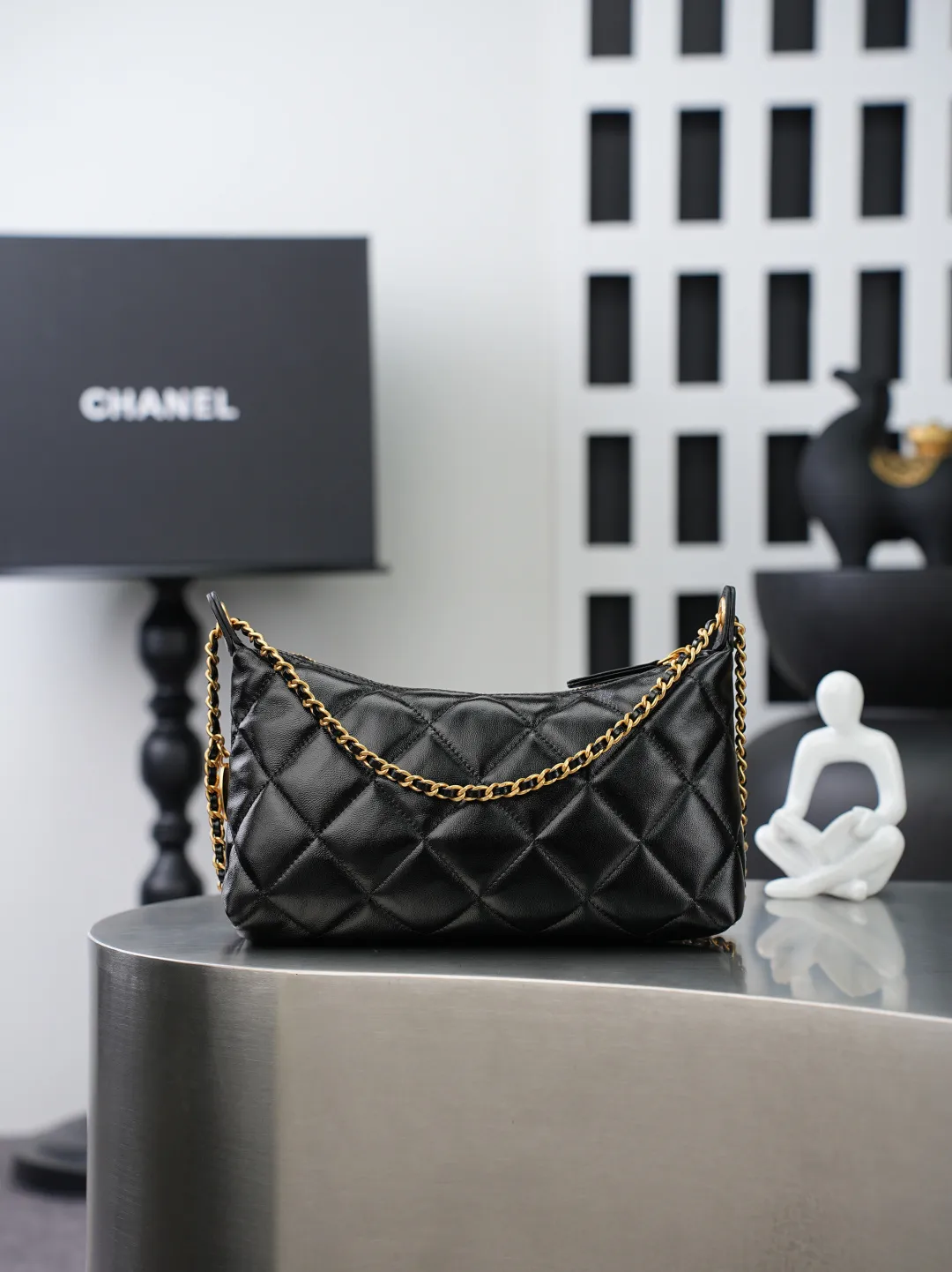💼𝑪𝒉𝒂𝒏𝒆𝒍 𝟐𝟓𝑺 | 腋下包𝒉𝒐𝒃𝒐👜 💜独家背景💜实物实拍/顶级质量 ✨细腻饱满的黑色小羊皮🖤，触感柔软顺滑，菱格绗缝走线工整利落，自带低调复古氛围。搭配穿皮金属链条，解锁腋下、单肩多种背法。内里为同色系衬里，搭配烫金标识，分层隔袋设计，轻松容纳日常随身物品。哑光金五金温润高级，整体兼具实用与格调💫，是日常通勤的百搭单品。 款号：𝑨𝑺 𝟓𝟓𝟐𝟖黑色羊皮 尺寸：𝟏𝟕*𝟐𝟔*𝟖.𝟓𝒄𝒎/带包装盒