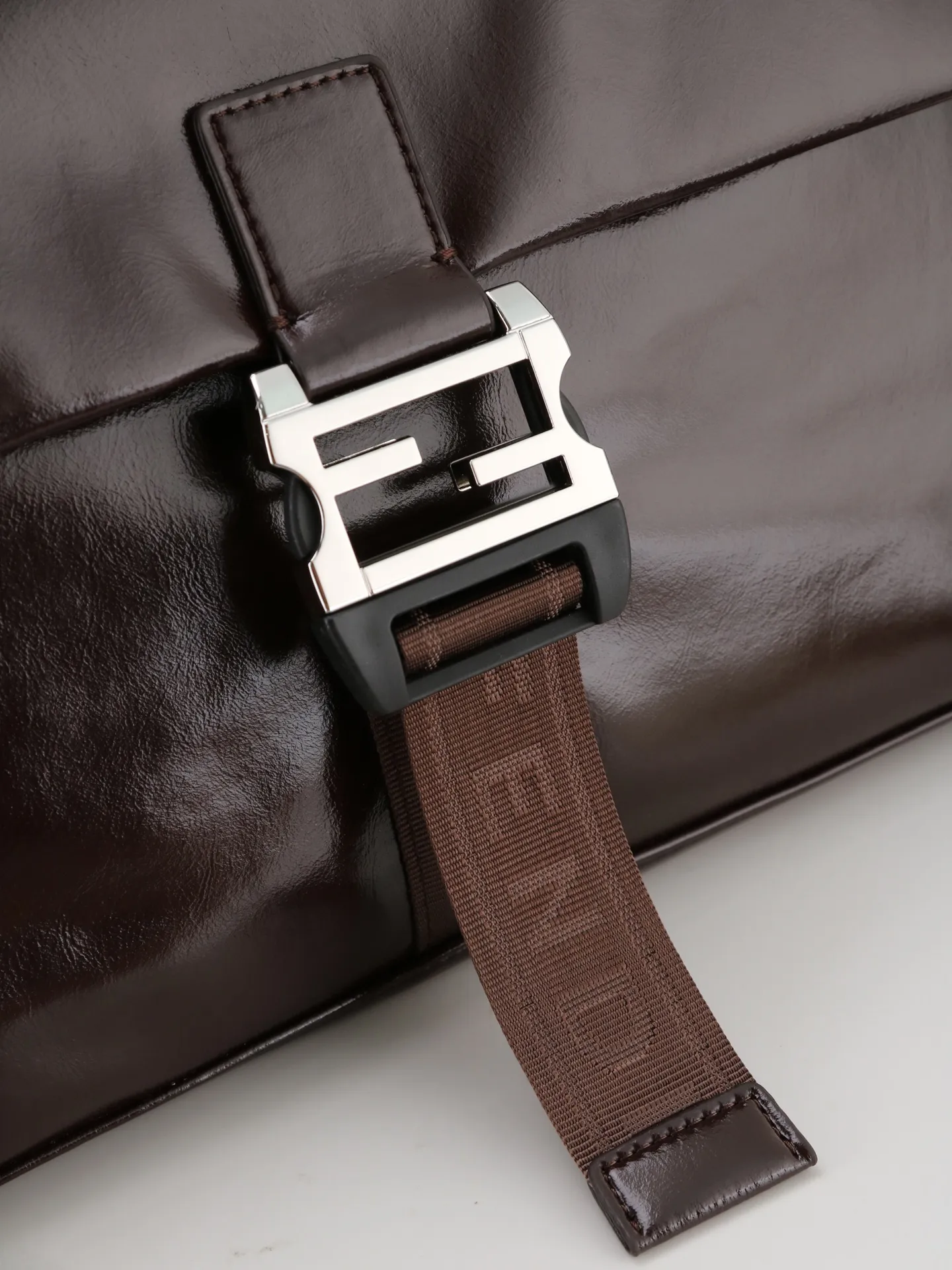 💰230 型号1122 配折叠盒 芬迪Fendi Flux信使包​​ 🖤Fendi Flux信使包，简约大气设计，搭配标志性金属&ldquo;F&rdquo;扣，辨识度超高✨。抽绳+翻盖双重开合，安全又方便。肩带可调节，支持手提、单肩、斜挎多种背法，通勤休闲都OK！内部空间超大，日常物品轻松装下，实用又时髦，是功能与设计感兼具的高端包包💼 尺寸35 22