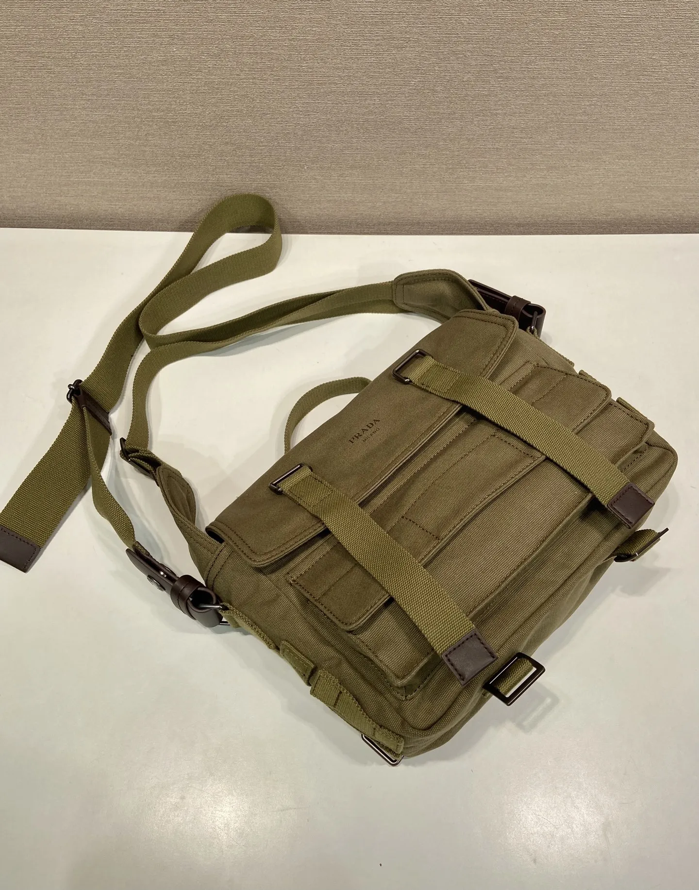 批650 特级原厂🎉新品邮差包🎉1BD408帆布🎉🎉\n这款邮差帆布包的设计灵感来源，它造型简洁大方，配有手拿柄和肩带，方便多种携带方式。内部空间宽敞，设有多个口袋，足以容纳工作或休闲时所需的各种物品。这种极简的设计理念让这款包成为一款多功能、充满现代感的配饰，将实用性完美地转化为一种独特的风格体现。太太好看，帅哥们，赶紧入手吧，又是一款永久不过时爆款🎉🎉\n长27x高20x底10cm🎉🎉🎉💰💰💰
