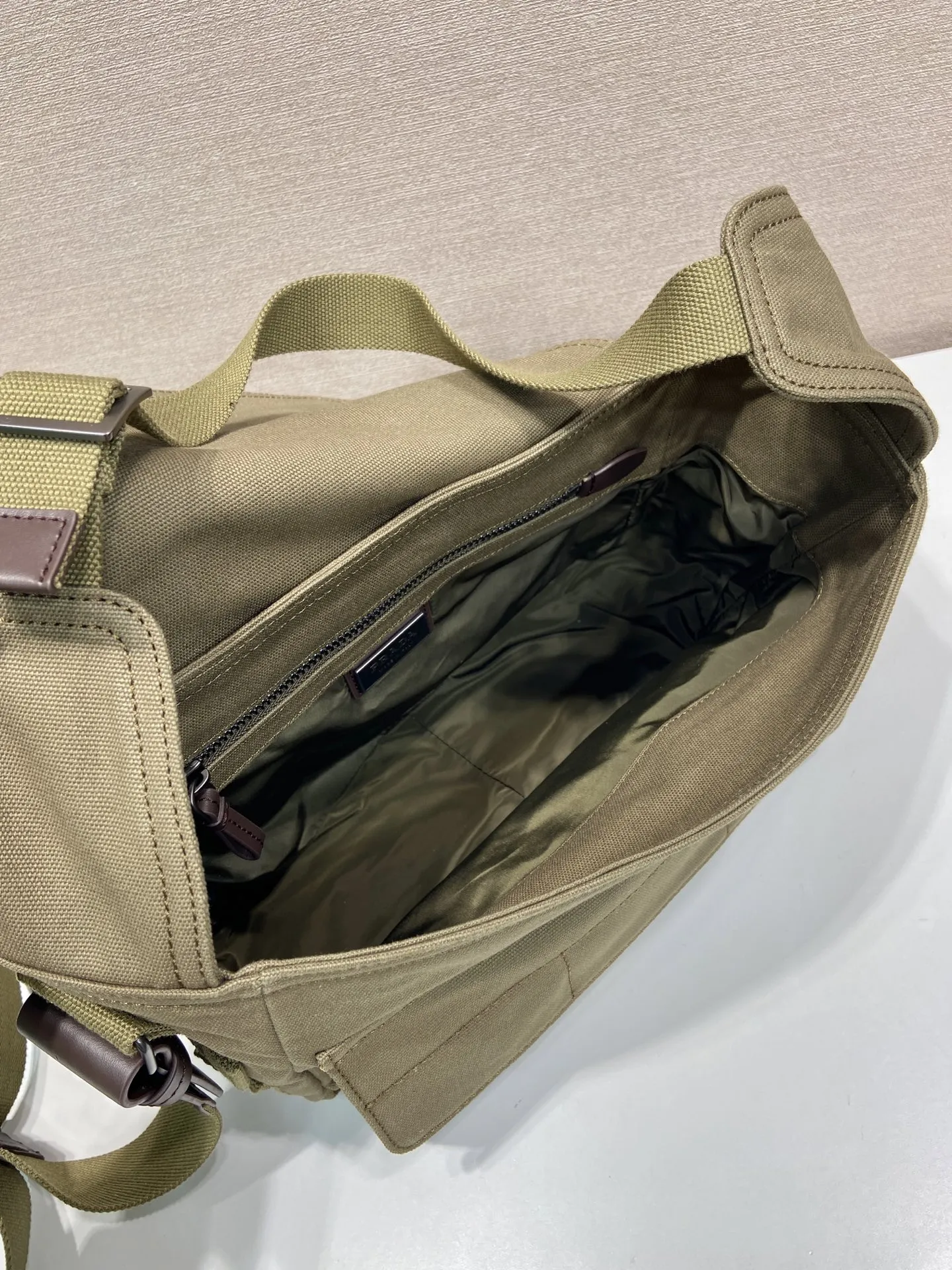 批650 特级原厂🎉新品邮差包🎉1BD408帆布🎉🎉\n这款邮差帆布包的设计灵感来源，它造型简洁大方，配有手拿柄和肩带，方便多种携带方式。内部空间宽敞，设有多个口袋，足以容纳工作或休闲时所需的各种物品。这种极简的设计理念让这款包成为一款多功能、充满现代感的配饰，将实用性完美地转化为一种独特的风格体现。太太好看，帅哥们，赶紧入手吧，又是一款永久不过时爆款🎉🎉\n长27x高20x底10cm🎉🎉🎉💰💰💰