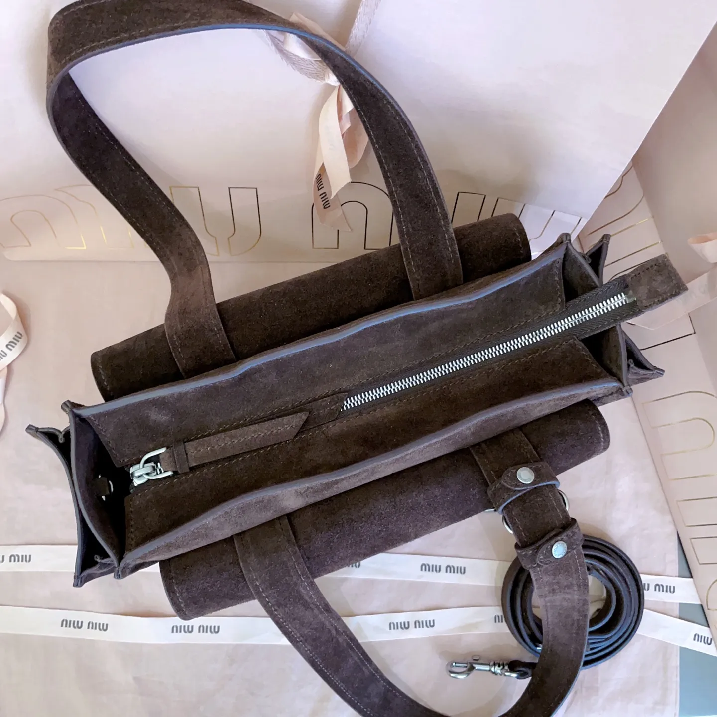 5BG335,Miu新品特色款式中古邮差包,超重工制做,超火麂皮材质,呈现百搭复古风格,多口袋元素与精美的五金配件彰显质感与实用性,延续 miu不拘一格,大胆创新,慵懒不鞍却又自然洒脱的风格,气场十足,能驾驭各种风格,上班通勤外出旅游都是绝佳选择,容量相当可光 尺寸:28X17.5X9cm