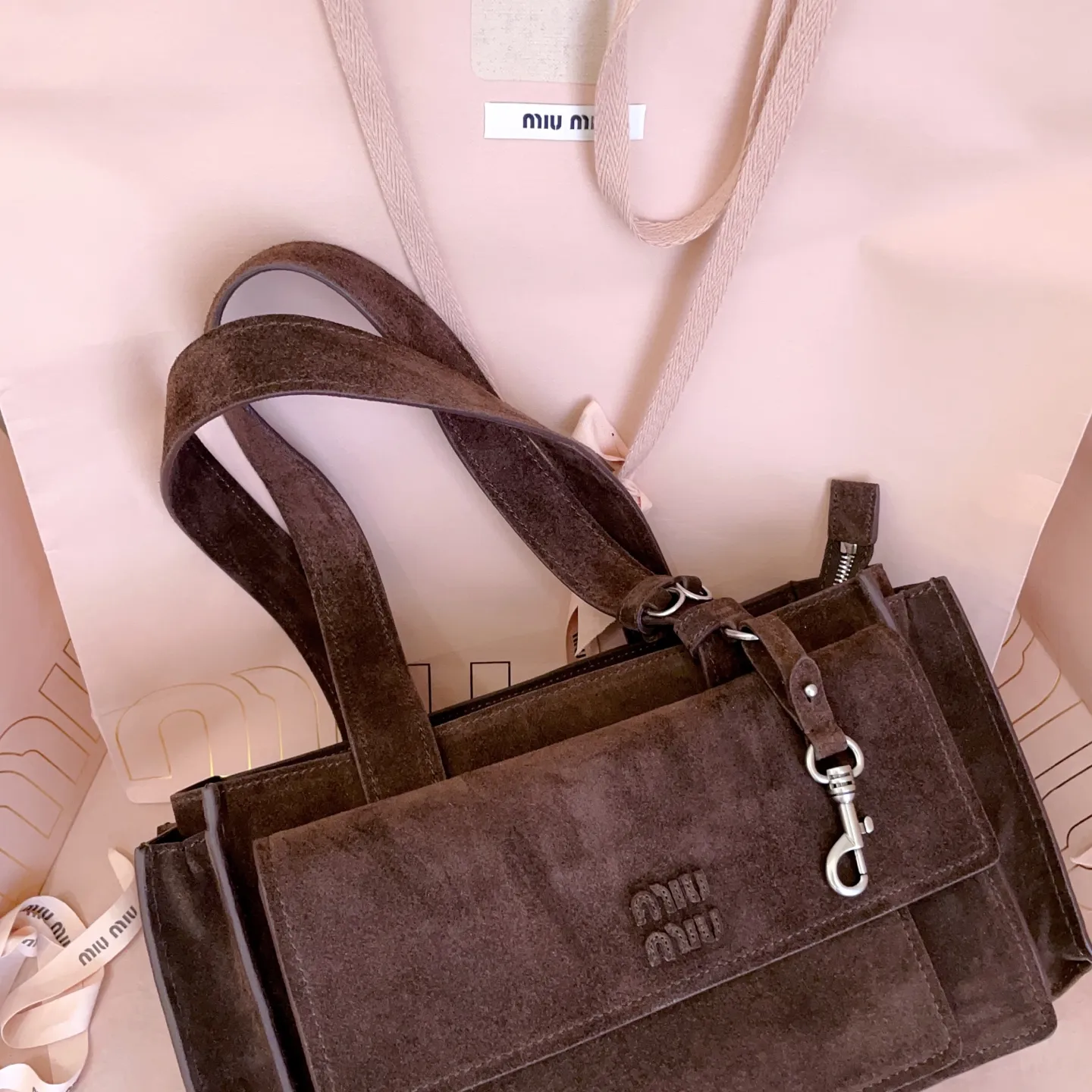 5BG335,Miu新品特色款式中古邮差包,超重工制做,超火麂皮材质,呈现百搭复古风格,多口袋元素与精美的五金配件彰显质感与实用性,延续 miu不拘一格,大胆创新,慵懒不鞍却又自然洒脱的风格,气场十足,能驾驭各种风格,上班通勤外出旅游都是绝佳选择,容量相当可光 尺寸:28X17.5X9cm