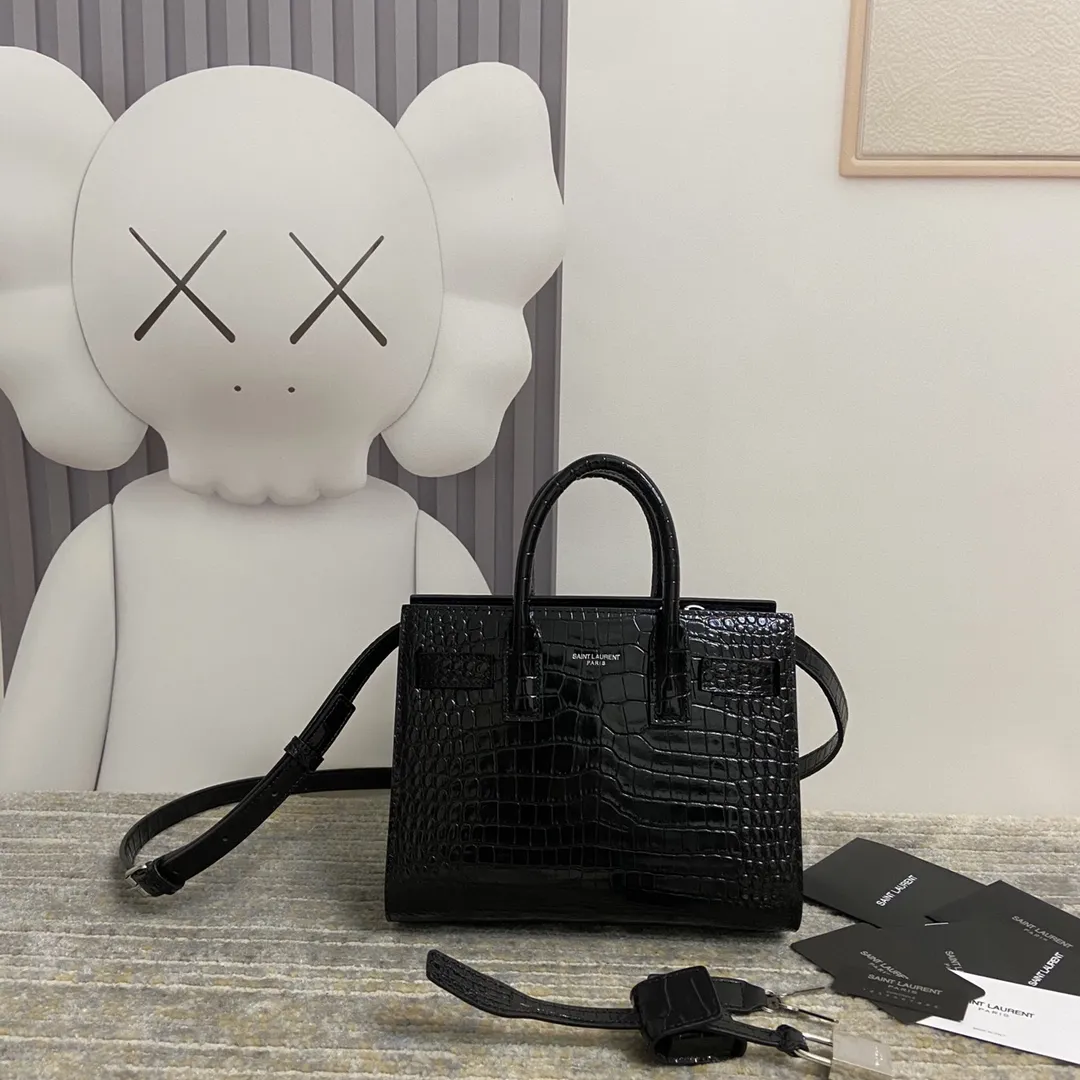 YSL经典Le Sac de Jour鳄纹手提包小号 经典SAINT LAURENT手袋、配以皮革管状手柄，风琴式侧面设 有按扣，搭配可调节可拆卸皮革斜挎背带和可拆卸皮套包覆型挂锁。上班通勤做公文包真的太太太太合适了！低调又非常有质感&hellip;get起同款包包！🔓 款号：392035 尺寸：21*15*10 💰920