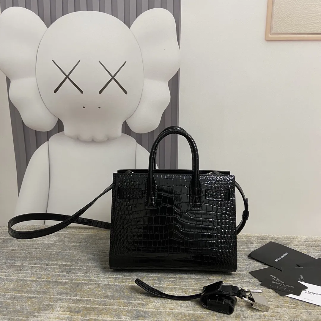YSL经典Le Sac de Jour鳄纹手提包小号 经典SAINT LAURENT手袋、配以皮革管状手柄,风琴式侧面设 有按扣,搭配可调节可拆卸皮革斜挎背带和可拆卸皮套包覆型挂锁。上班通勤做公文包真的太太太太合适了!低调又非常有质感…get起同款包包!🔓 款号:392035 尺寸:21*15*10 💰920