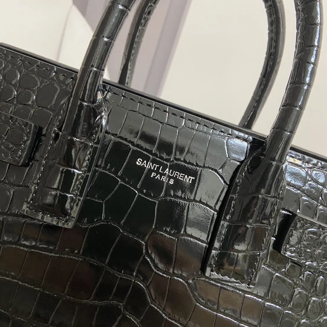 YSL经典Le Sac de Jour鳄纹手提包小号 经典SAINT LAURENT手袋、配以皮革管状手柄，风琴式侧面设 有按扣，搭配可调节可拆卸皮革斜挎背带和可拆卸皮套包覆型挂锁。上班通勤做公文包真的太太太太合适了！低调又非常有质感&hellip;get起同款包包！🔓 款号：392035 尺寸：21*15*10 💰920
