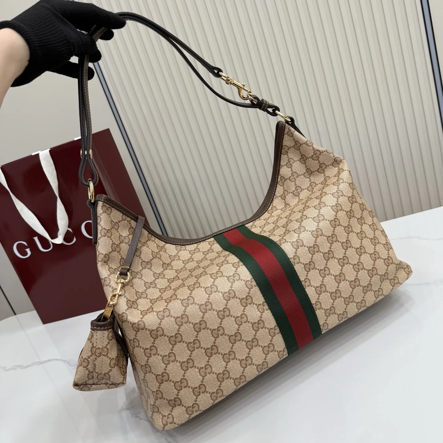 p580。【配全套包装】‼️Generation Gucci古驰世代系列深入探索品牌的典藏元素，将不同世代的设计融合为统一的美学叙事。全新单肩包，兼具多功能与精致感，可斜挎或肩背。可拆卸迷你包可收纳AirPods及小件物品，增添实用而灵动的细节。 沙色和深棕色GG涂层帆布 棕色皮革滚边 金色调配件 织带 GG涂层帆布和棕色棉布衬里 双拉链开合 型号：A008NS。 尺寸：39.5厘米（宽）x 29厘米（高）x 15.5厘米（深） 滑动肩链带高：31厘米 - 54厘米 颜色：杏色/水晶。 意大利创作
