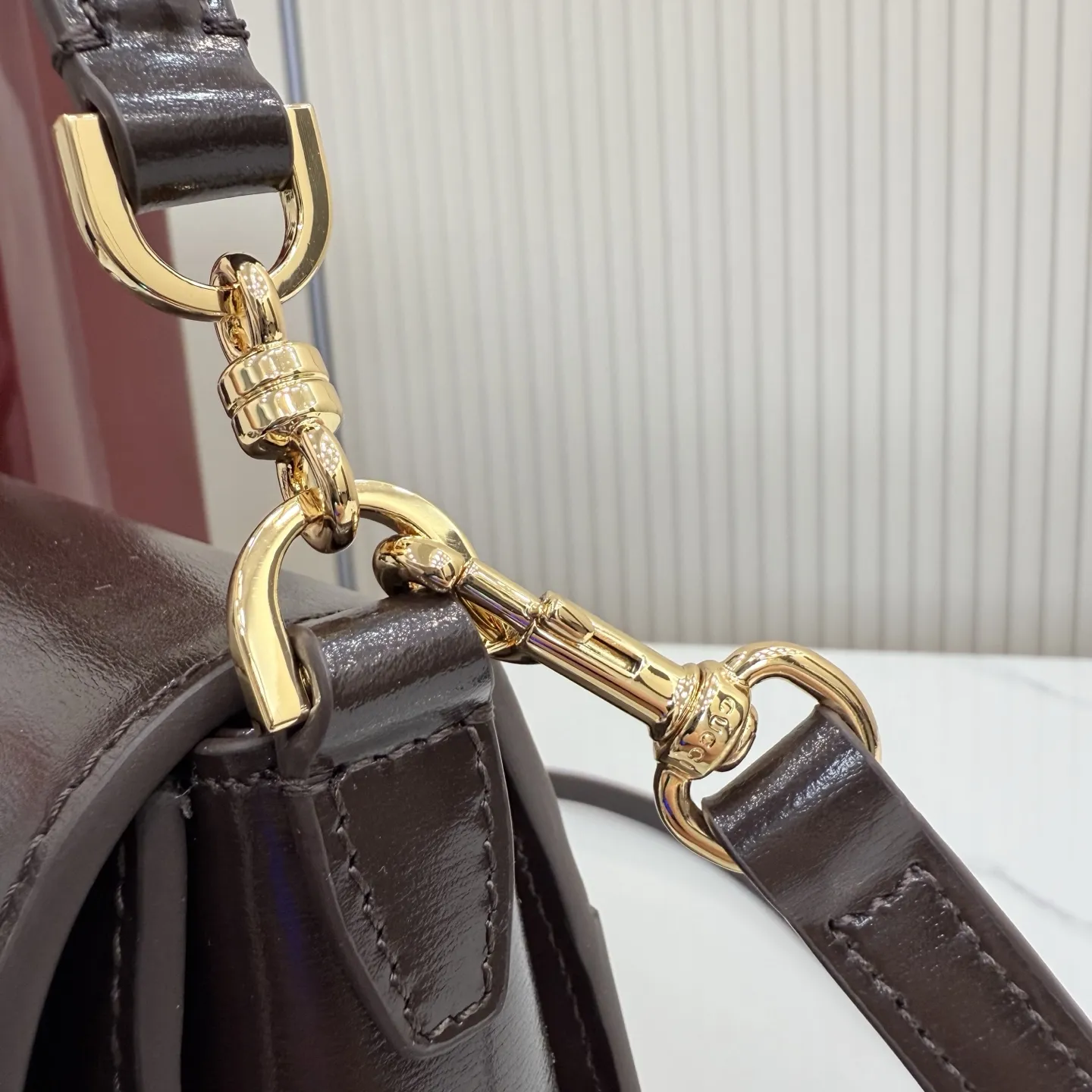 p830。【配全套包装】‼️Gucci Primavera系列通过融合创新与务实的愿景,确立了廓形、质地与材质的新语汇。这款顶部提手包采用光泽皮革打造,质地柔软,廓形简洁,可作为手提包、单肩包或斜挎包背携。包身配有品牌标志性的马衔扣配件。 金属支脚 内部:1个拉链口袋 外部:1个后袋 皮革顶部提手垂直高度:15厘米;长度:44厘米 可拆卸和可调节皮革肩带下垂长度:47 - 53.5厘米;长度:98 - 113厘米 翻盖开合 型号:A006N6。 尺寸:27.5厘米(宽)x 19厘米(高)x 9厘米(深) 重量:约0.7千克 颜色:深巧色/全皮。 意大利创作