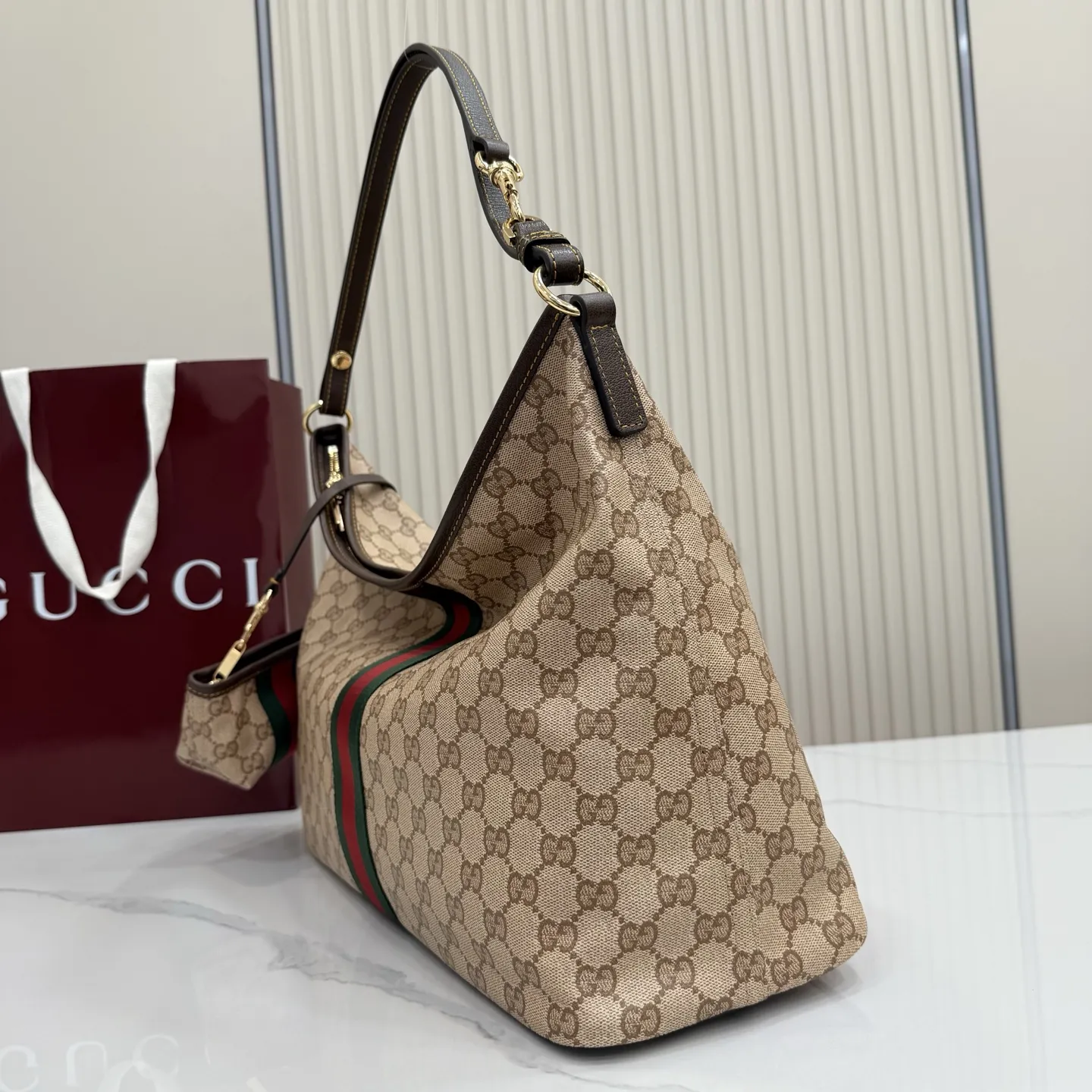 p580。【配全套包装】‼️Generation Gucci古驰世代系列深入探索品牌的典藏元素，将不同世代的设计融合为统一的美学叙事。全新单肩包，兼具多功能与精致感，可斜挎或肩背。可拆卸迷你包可收纳AirPods及小件物品，增添实用而灵动的细节。 沙色和深棕色GG涂层帆布 棕色皮革滚边 金色调配件 织带 GG涂层帆布和棕色棉布衬里 双拉链开合 型号：A008NS。 尺寸：39.5厘米（宽）x 29厘米（高）x 15.5厘米（深） 滑动肩链带高：31厘米 - 54厘米 颜色：杏色/水晶。 意大利创作