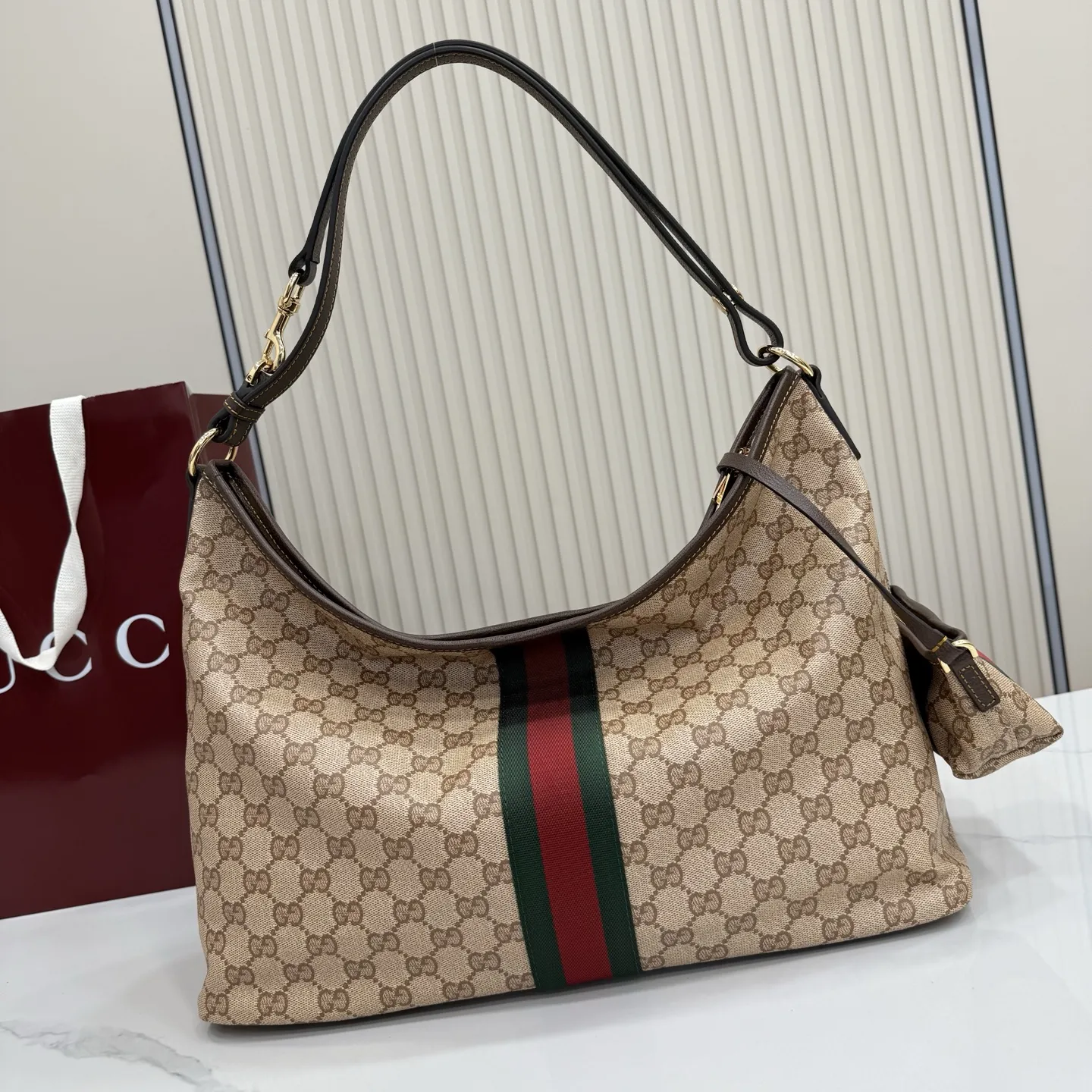 p580。【配全套包装】‼️Generation Gucci古驰世代系列深入探索品牌的典藏元素，将不同世代的设计融合为统一的美学叙事。全新单肩包，兼具多功能与精致感，可斜挎或肩背。可拆卸迷你包可收纳AirPods及小件物品，增添实用而灵动的细节。 沙色和深棕色GG涂层帆布 棕色皮革滚边 金色调配件 织带 GG涂层帆布和棕色棉布衬里 双拉链开合 型号：A008NS。 尺寸：39.5厘米（宽）x 29厘米（高）x 15.5厘米（深） 滑动肩链带高：31厘米 - 54厘米 颜色：杏色/水晶。 意大利创作
