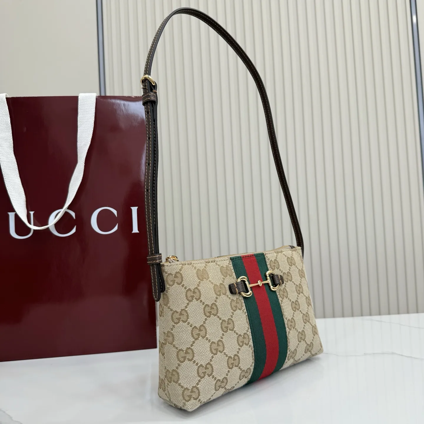 p420。【配全套包装】‼️Generation Gucci古驰世代系列深入探索品牌的典藏元素,将不同世代的设计融合为统一的美学叙事。小皮具设计向马衔扣致敬,将标志性配件细节与Web条纹织带融合,注入复古优雅气息。这款款式采用GG帆布制作,并配有可调节肩带。 沙色和深棕色GG帆布 棕色皮革滚边 金色调配件 沙色帆布衬里,饰有钻石菱格纹图案和棕色塔夫绸衬里 马衔扣、织带和意大利创作Gucci标识 内部:3个卡片隔层 可调节皮革肩带,下垂长度:30厘米 拉链封口 型号:867130。 尺寸:20厘米(宽)x 12.5厘米(高)x 4.5厘米(下深)x 1.5厘米(上深) 重量:约 166 克 颜色:杏布/棕色。 意大利创作