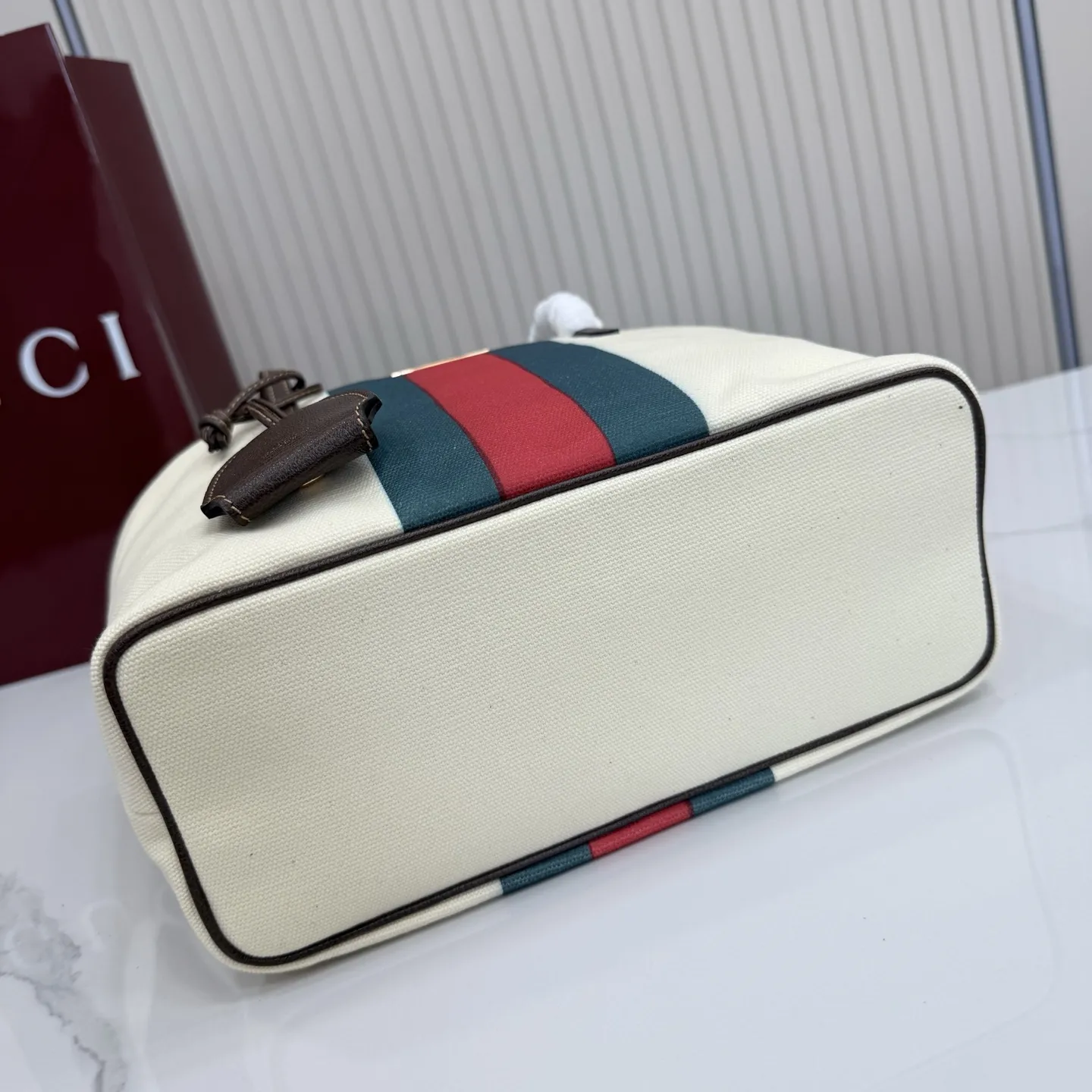 p480。【配全套包装】‼️Generation Gucci系列深入探索品牌典藏元素，将不同世代的设计融入一体，营造出独特的美学叙事。水洗GG帆布为精致廓形增添品牌标识性细节，如这款托特包，通过魅力装饰和品牌标识徽牌，将日常风格提升至新高度。 天然水洗帆布 棕色皮革滚边 金色调配件 棕色皮革吊饰 米色和深棕色棉质衬里 提手下垂：23厘米 饰按扣闭合 型号：A0034E。 尺寸：25厘米（宽）x 19厘米（高）x 11.5厘米（深） 重量：约260克 颜色：棕色/帆布。 意大利创作