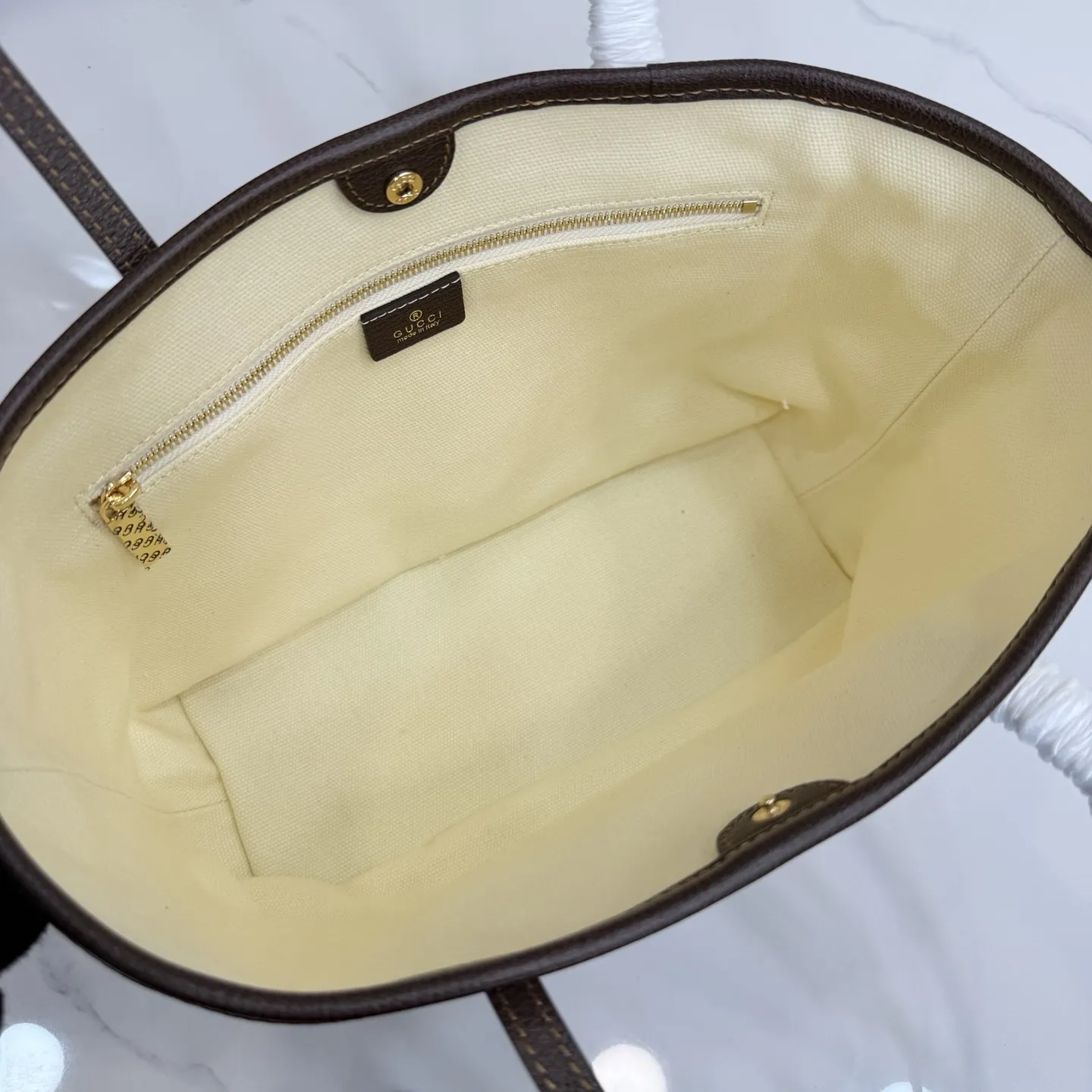 p480。【配全套包装】‼️Generation Gucci系列深入探索品牌典藏元素,将不同世代的设计融入一体,营造出独特的美学叙事。水洗GG帆布为精致廓形增添品牌标识性细节,如这款托特包,通过魅力装饰和品牌标识徽牌,将日常风格提升至新高度。 天然水洗帆布 棕色皮革滚边 金色调配件 棕色皮革吊饰 米色和深棕色棉质衬里 提手下垂:23厘米 饰按扣闭合 型号:A0034E。 尺寸:25厘米(宽)x 19厘米(高)x 11.5厘米(深) 重量:约260克 颜色:棕色/帆布。 意大利创作