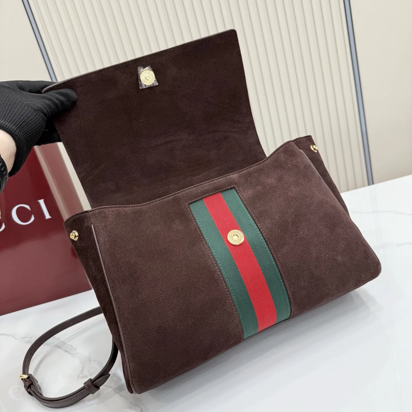 p710。【配全套包装】‼️Gucci Primavera系列通过融合创新与务实的愿景,确立了廓形、质地与材质的新语汇。这款Paparazzo系列手袋以时尚、挺括的廓形为特征,配有品牌标识性的条纹织带。翻盖隐藏磁扣闭合,安全固定内部物品,单根顶部提手和可拆卸皮革肩带设计,提供多样化的佩戴方式。 深棕色软皮 金色调配件 深棕色帆布衬里,饰钻石菱格纹图案 马衔扣 饰按扣开合 内部:1个拉链口袋,1个开口口袋 手柄垂直高度:17厘米 可拆卸和可调节皮革肩带长度:42 - 54厘米;长度:93 - 112厘米 磁扣开合 型号:875018。 尺寸:30厘米(宽)x 21厘米(高)x 12厘米(深) 重量:约685克 颜色:深棕色/磨砂。 意大利创作