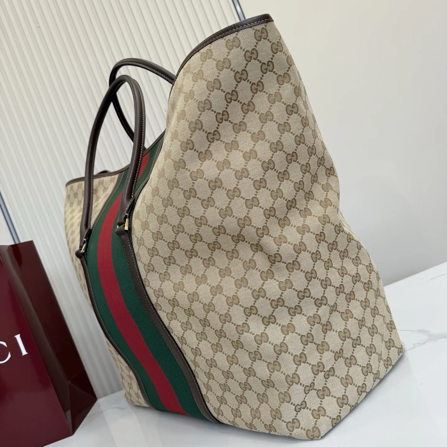 p630。‼️Generation Gucci系列深入探索品牌典藏元素，将不同年代的设计融合成一种美学叙事。GG涂层帆布搭配织带，为精致廓形增添品牌标识性元素，例如这款旅行包，提升日常使用体验。 沙色和深棕色GG涂层帆布 棕色皮革滚边 金色调配件 织带 棕色棉布衬里 型号：874979。 尺寸：47厘米（宽）x45厘米（高）x19.8厘米（侧宽）。 颜色：杏布/棕色。