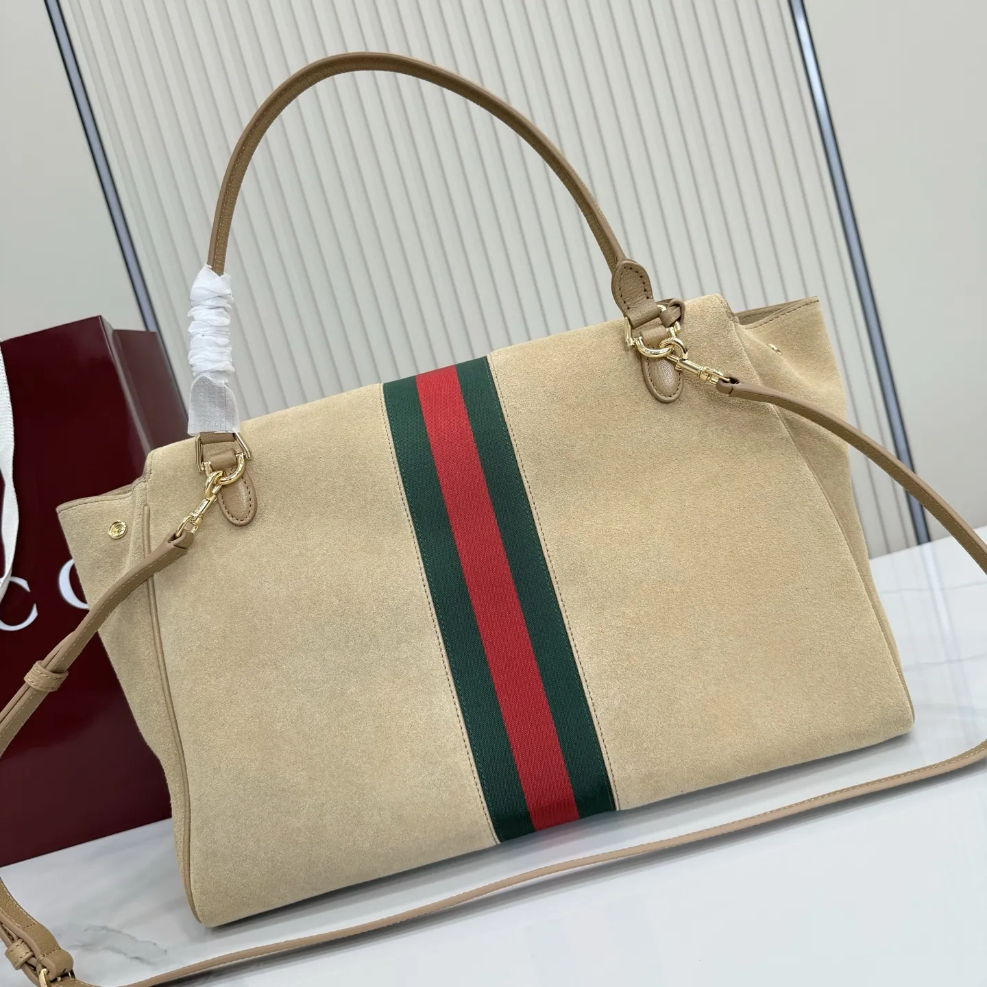 p790。【配全套包装】‼️Generation Gucci古驰世代系列深入探索品牌的典藏元素，将不同世代的设计融合为统一的美学叙事。这款款式以手提包设计向品牌标志性的马衔扣元素致敬，柔软的绒面皮革呈现精致的配色。 沙色柔软绒面材质 沙色皮革滚边 金色调配件 沙色帆布衬里，饰Diamante图案 马衔扣、织带和皮革标牌，带有&ldquo;Made in Italy Gucci&rdquo;标志 饰按扣 内部：1个拉链口袋，1个开口口袋 手柄垂直高度：18-24.5厘米 可拆卸和可调节皮革肩带下垂长度：51 - 55厘米； 磁扣开合 型号：875019。 尺寸：37厘米（宽）x 29厘米（高）x 13厘米（深） 重量：约825克 颜色：杏色/绒皮。 意大利创作