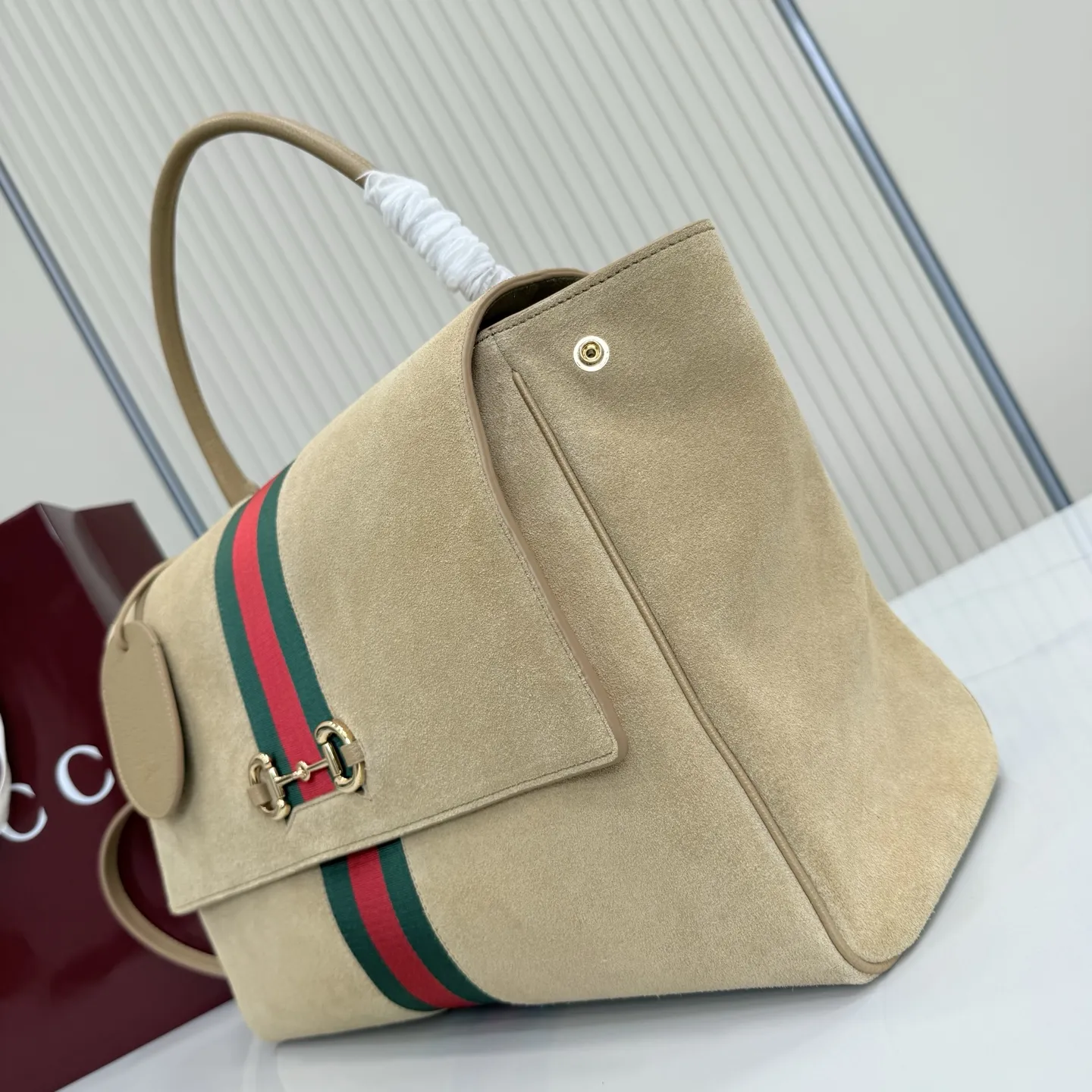 p790。【配全套包装】‼️Generation Gucci古驰世代系列深入探索品牌的典藏元素，将不同世代的设计融合为统一的美学叙事。这款款式以手提包设计向品牌标志性的马衔扣元素致敬，柔软的绒面皮革呈现精致的配色。 沙色柔软绒面材质 沙色皮革滚边 金色调配件 沙色帆布衬里，饰Diamante图案 马衔扣、织带和皮革标牌，带有&ldquo;Made in Italy Gucci&rdquo;标志 饰按扣 内部：1个拉链口袋，1个开口口袋 手柄垂直高度：18-24.5厘米 可拆卸和可调节皮革肩带下垂长度：51 - 55厘米； 磁扣开合 型号：875019。 尺寸：37厘米（宽）x 29厘米（高）x 13厘米（深） 重量：约825克 颜色：杏色/绒皮。 意大利创作