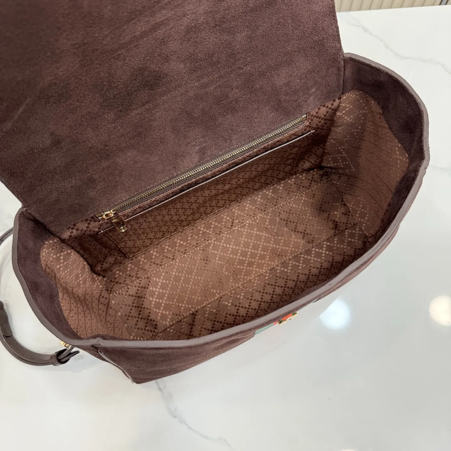 p710。【配全套包装】‼️Gucci Primavera系列通过融合创新与务实的愿景，确立了廓形、质地与材质的新语汇。这款Paparazzo系列手袋以时尚、挺括的廓形为特征，配有品牌标识性的条纹织带。翻盖隐藏磁扣闭合，安全固定内部物品，单根顶部提手和可拆卸皮革肩带设计，提供多样化的佩戴方式。 深棕色软皮 金色调配件 深棕色帆布衬里，饰钻石菱格纹图案 马衔扣 饰按扣开合 内部：1个拉链口袋，1个开口口袋 手柄垂直高度：17厘米 可拆卸和可调节皮革肩带长度：42 - 54厘米；长度：93 - 112厘米 磁扣开合 型号：875018。 尺寸：30厘米（宽）x 21厘米（高）x 12厘米（深） 重量：约685克 颜色：深棕色/磨砂。 意大利创作