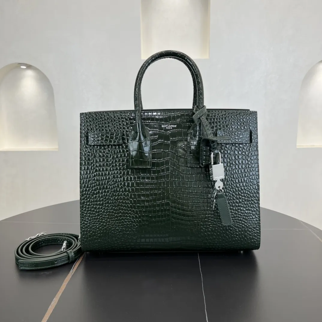经典 SAC DE JOUR 大号鳄鱼纹压花闪亮真皮手袋经典 SAINT LAURENT 手袋，管状提手，侧面手风琴式皱褶，松紧调解皮带附吊牌，镌刻 SAINT LAURENT 标志，可拆卸肩带。货号 378299 💰1020 尺寸 32.0 25.0 16.5 CM100% 小羊皮革衬里银色调五金可拆卸皮革外包挂锁可拆卸中央拉链袋铜脚臂垂：9.5 CM肩带垂饰：48 CM