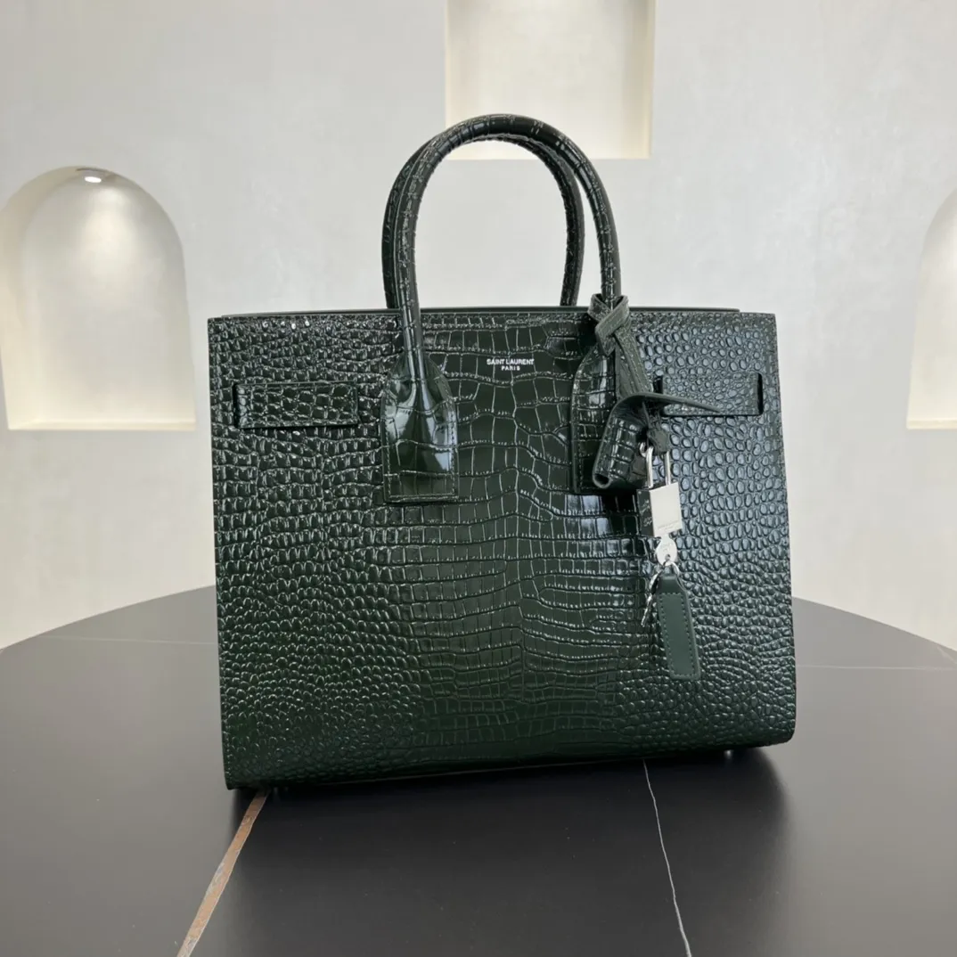 经典 SAC DE JOUR 大号鳄鱼纹压花闪亮真皮手袋经典 SAINT LAURENT 手袋，管状提手，侧面手风琴式皱褶，松紧调解皮带附吊牌，镌刻 SAINT LAURENT 标志，可拆卸肩带。货号 378299 💰1020 尺寸 32.0 25.0 16.5 CM100% 小羊皮革衬里银色调五金可拆卸皮革外包挂锁可拆卸中央拉链袋铜脚臂垂：9.5 CM肩带垂饰：48 CM