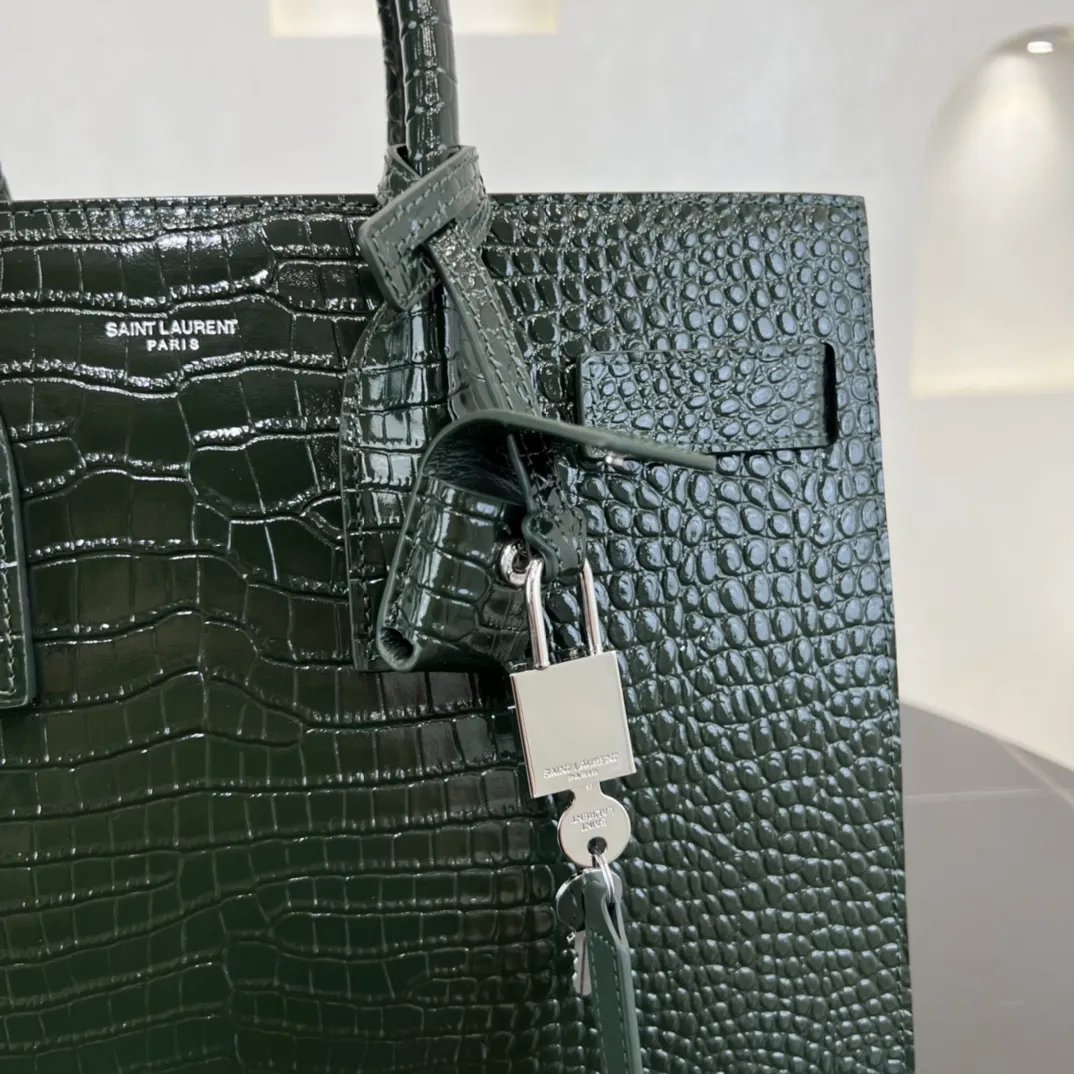 经典 SAC DE JOUR 大号鳄鱼纹压花闪亮真皮手袋经典 SAINT LAURENT 手袋,管状提手,侧面手风琴式皱褶,松紧调解皮带附吊牌,镌刻 SAINT LAURENT 标志,可拆卸肩带。货号 378299 💰1020 尺寸 32.0 25.0 16.5 CM100% 小羊皮革衬里银色调五金可拆卸皮革外包挂锁可拆卸中央拉链袋铜脚臂垂:9.5 CM肩带垂饰:48 CM