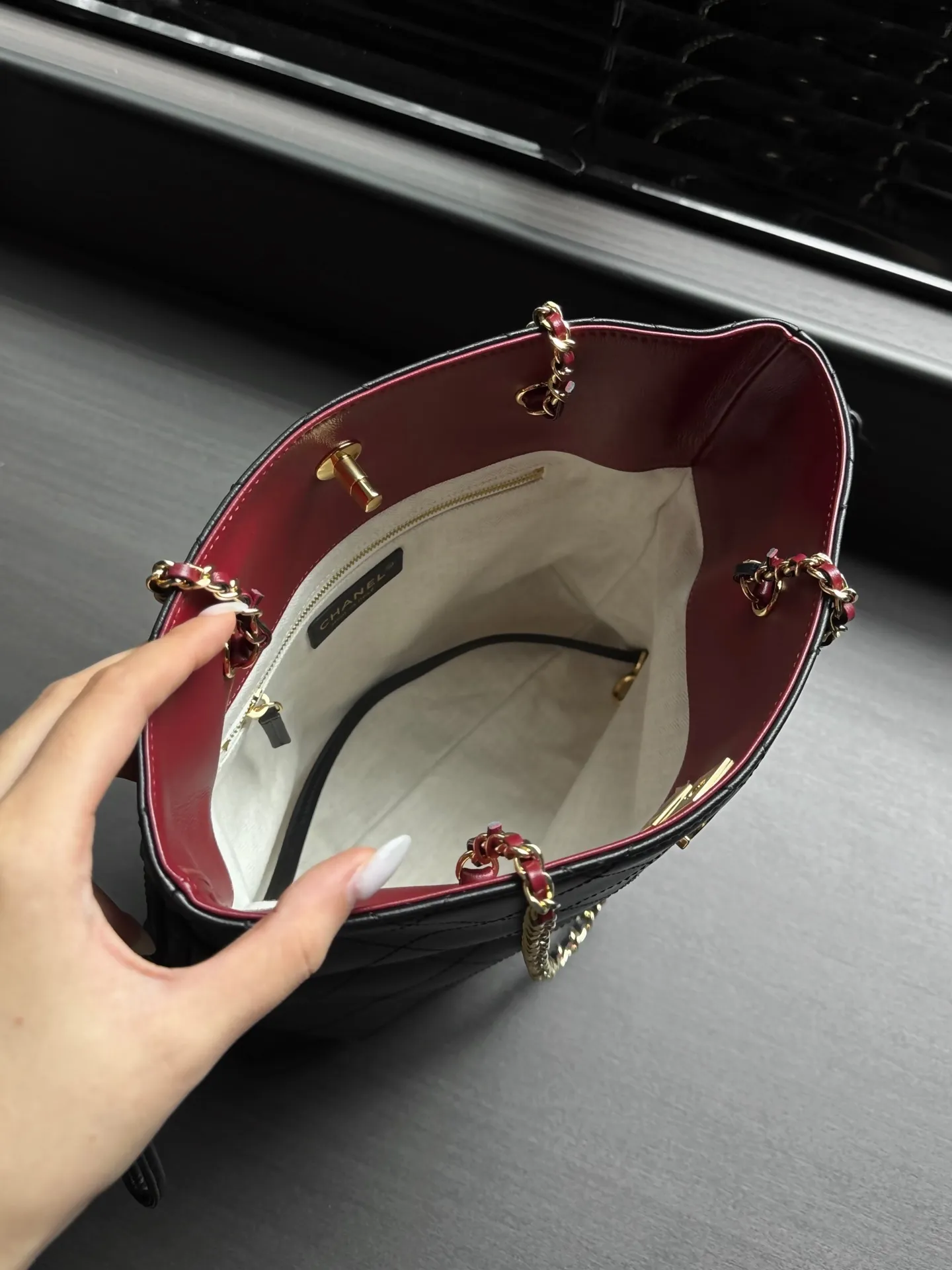 💰850 26B福袋托特 松弛感通勤天花板 黑金菱格福袋包真的越看越上头✨ 软糯细腻的牛皮材质,大菱格纹路高级感拉满,经典双C金扣低调显贵。 侧边自带抽绳设计,想随性松弛就放开,收紧又变成精致福袋造型,一包两种风格。 皮穿链肩带,单肩背利落大气,不压肩膀。 内里酒红撞色内衬,容量超能打,iPad、雨伞、水杯统统装得下,日常通勤、逛街出行都适配。 款号AS6495 尺寸34-28-12 配包装