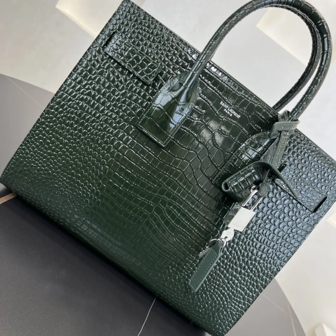 经典 SAC DE JOUR 大号鳄鱼纹压花闪亮真皮手袋经典 SAINT LAURENT 手袋,管状提手,侧面手风琴式皱褶,松紧调解皮带附吊牌,镌刻 SAINT LAURENT 标志,可拆卸肩带。货号 378299 💰1020 尺寸 32.0 25.0 16.5 CM100% 小羊皮革衬里银色调五金可拆卸皮革外包挂锁可拆卸中央拉链袋铜脚臂垂:9.5 CM肩带垂饰:48 CM