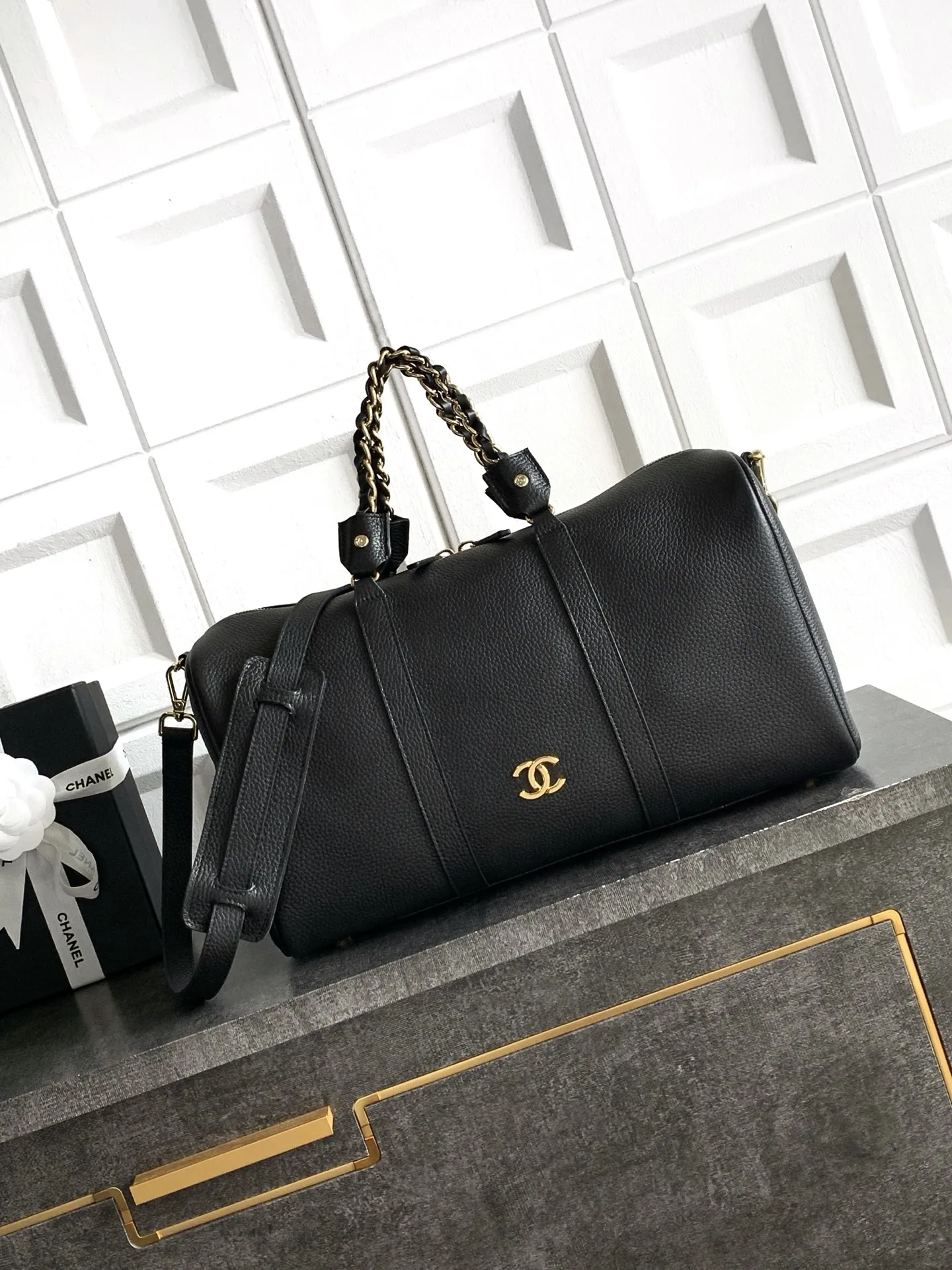 预定中🆕🆕🆕OHANEL🪞🪞🪞27c波士顿保龄球包（Boston Bowling Bag）​​，也就是你之前关注的那只 Kendall 同款旅行袋的更小版本&mdash;&mdash;🤩黑色粒面小牛皮 + 金色双 C logo + 皮穿金链肩带 + 顶部短手柄，拉链开合，圆筒保龄球包型。和之前看的那个 27 早春大旅行袋相比，这只更日常：- ​​容量​​：🉑️手机、🉑️钱包、化妆品、钥匙都能装下，日常通勤和周末短途都够用，有人评价它是