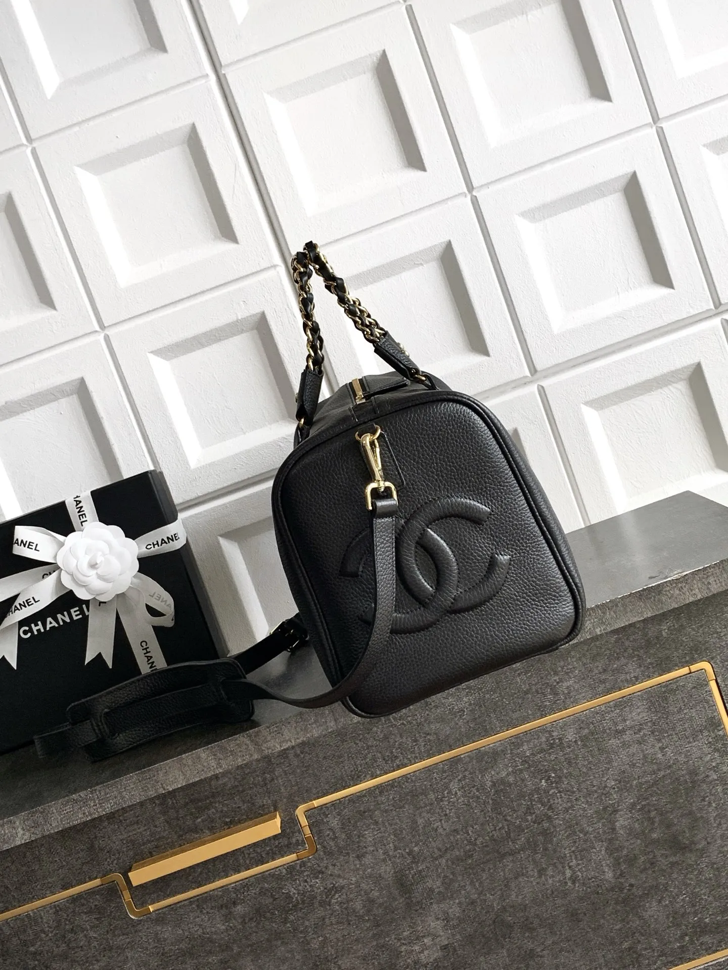 预定中🆕🆕🆕OHANEL🪞🪞🪞27c波士顿保龄球包（Boston Bowling Bag）​​，也就是你之前关注的那只 Kendall 同款旅行袋的更小版本&mdash;&mdash;🤩黑色粒面小牛皮 + 金色双 C logo + 皮穿金链肩带 + 顶部短手柄，拉链开合，圆筒保龄球包型。和之前看的那个 27 早春大旅行袋相比，这只更日常：- ​​容量​​：🉑️手机、🉑️钱包、化妆品、钥匙都能装下，日常通勤和周末短途都够用，有人评价它是