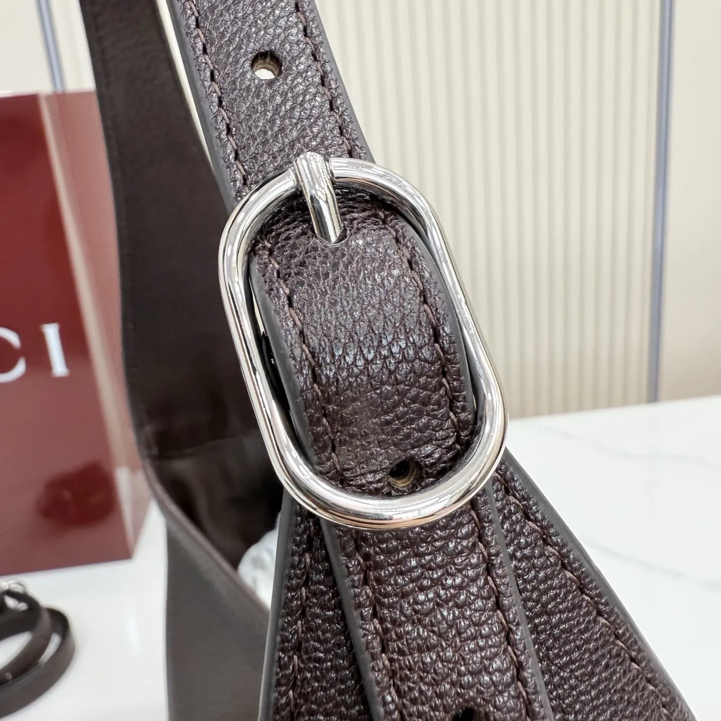 p750。【配全套包装】‼️（羊皮）2026春夏系列全新上市。这款Gucci Jackie 9161系列手袋呈现时髦风格，选用柔软粒面羊皮革，经手工悉心做旧处理，呈现出复古质感。手袋搭配便于使用的推入式锁扣设计，金色调金属配件更添品牌标志性五金细节的风格魅力。 型号：863136。 尺寸：31.5厘米（宽）x 22厘米（高）x 4.5厘米（深） 重量：约0.35千克 颜色：深棕色/羊皮。