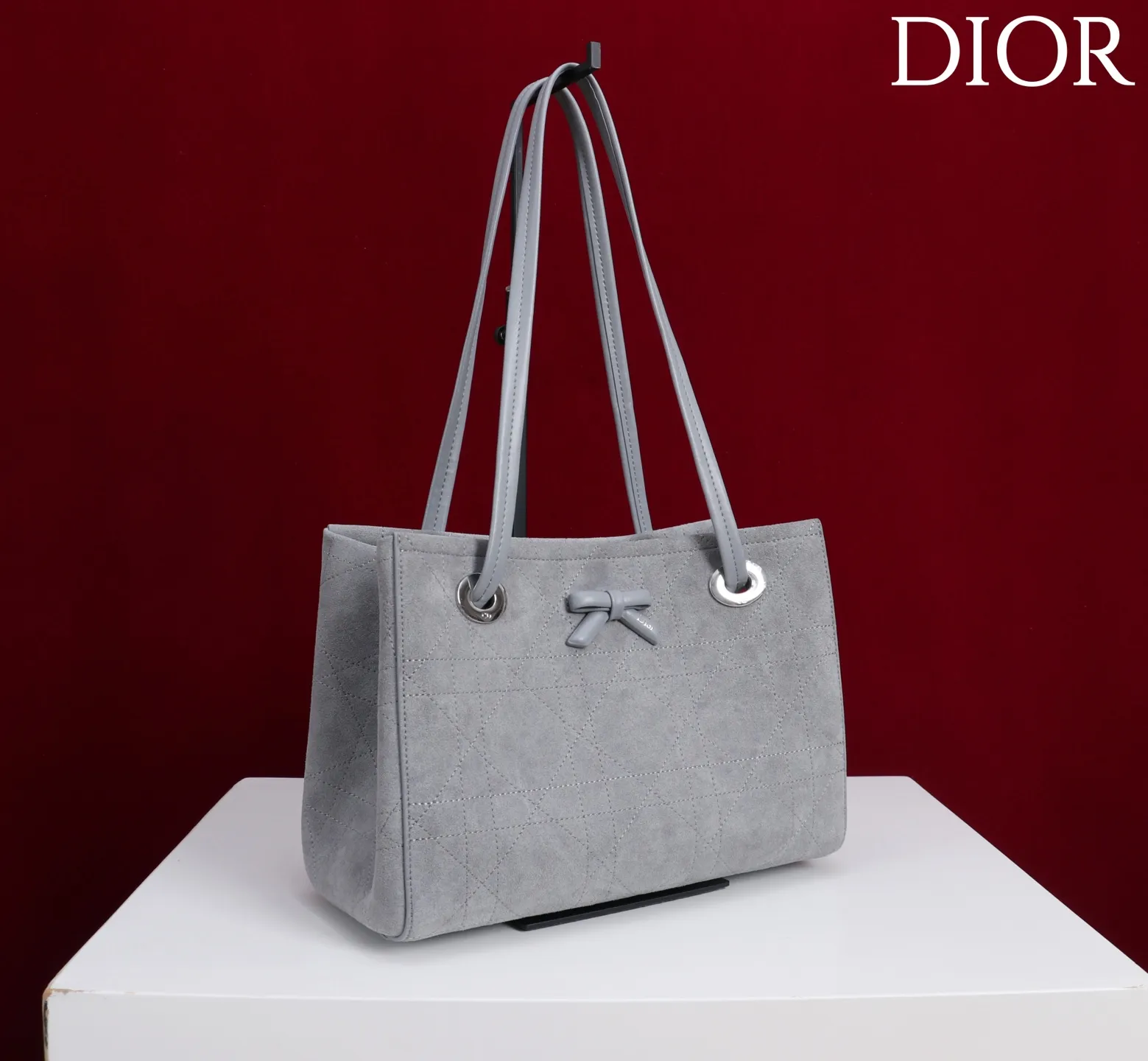 ❤️1410灰色绒布蝴蝶结\n这款购物袋由乔纳森·安德森 (Jonathan Anderson) 为 Dior 倾情打造,实用宽敞的设计饰以精美蝴蝶结提升格调,展现 Dior 的全新标志细节。小号款式,牛皮和皮革装饰等材质巧妙结合,柔软廓形和巧妙的滑动式顶部手柄别具一格,可手提、肩背或斜挎。\n主体:牛皮革,棉,科技面料\n里料:棉,亚麻,牛皮革\n磁性开合\n正面饰以 Dior 标志皮革蝴蝶结\n顶部滑动式皮革手柄,搭配 CD 标志孔眼\n内部拉链口袋\n内部插袋\n编号: M1410\n尺寸:27 x 19 x 13.5 厘米(长 x 高 x 宽)
