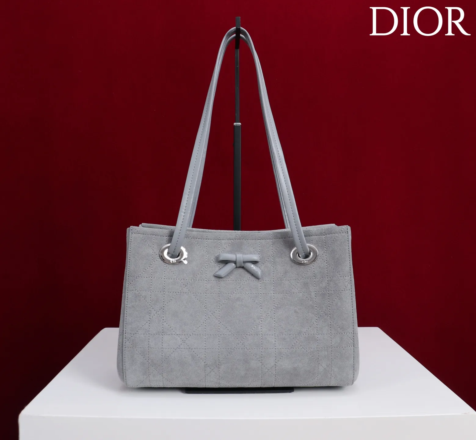 ❤️1410灰色绒布蝴蝶结\n这款购物袋由乔纳森·安德森 (Jonathan Anderson) 为 Dior 倾情打造,实用宽敞的设计饰以精美蝴蝶结提升格调,展现 Dior 的全新标志细节。小号款式,牛皮和皮革装饰等材质巧妙结合,柔软廓形和巧妙的滑动式顶部手柄别具一格,可手提、肩背或斜挎。\n主体:牛皮革,棉,科技面料\n里料:棉,亚麻,牛皮革\n磁性开合\n正面饰以 Dior 标志皮革蝴蝶结\n顶部滑动式皮革手柄,搭配 CD 标志孔眼\n内部拉链口袋\n内部插袋\n编号: M1410\n尺寸:27 x 19 x 13.5 厘米(长 x 高 x 宽)