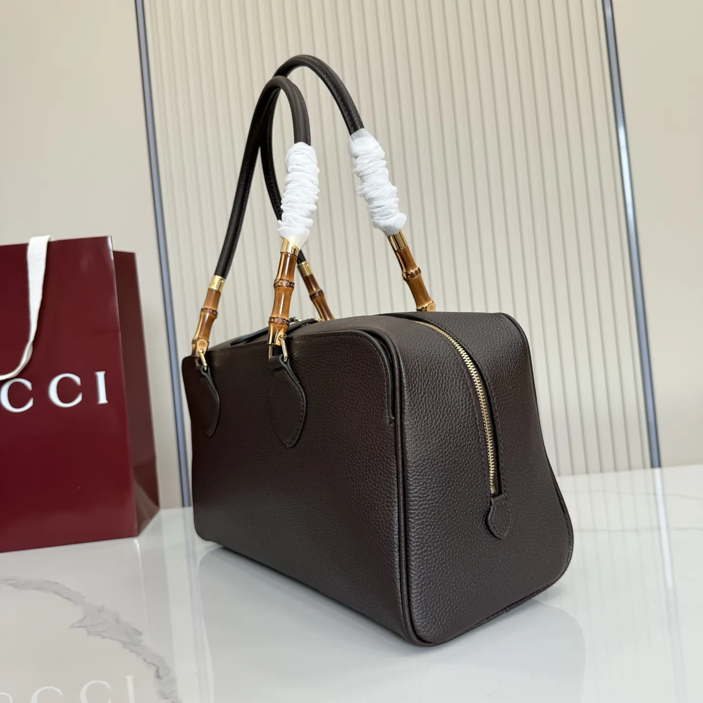 p820。【配全套包装】‼️Gucci Primavera系列通过融合创新与扎实的设计理念，为款式、质感和材质创造了全新语汇。这款多功能波士顿包设计中，品牌标志性的竹节元素以精致的点缀形式呈现，巧妙融入于精湛制作的皮革提手上，并配以金色调配件。 深棕色轻质皮革，半光泽表面 金色调配件 深棕色帆布衬里，饰钻石菱格纹图案 内部：1个拉链口袋 外部：1个开口口袋 手柄垂直高度：23厘米 双拉链封口 型号：A006OD。 尺寸：35.5厘米（宽）x 18厘米（高）x 14.5厘米（深） 重量：约1千克 颜色：深棕色/全皮。 意大利创作