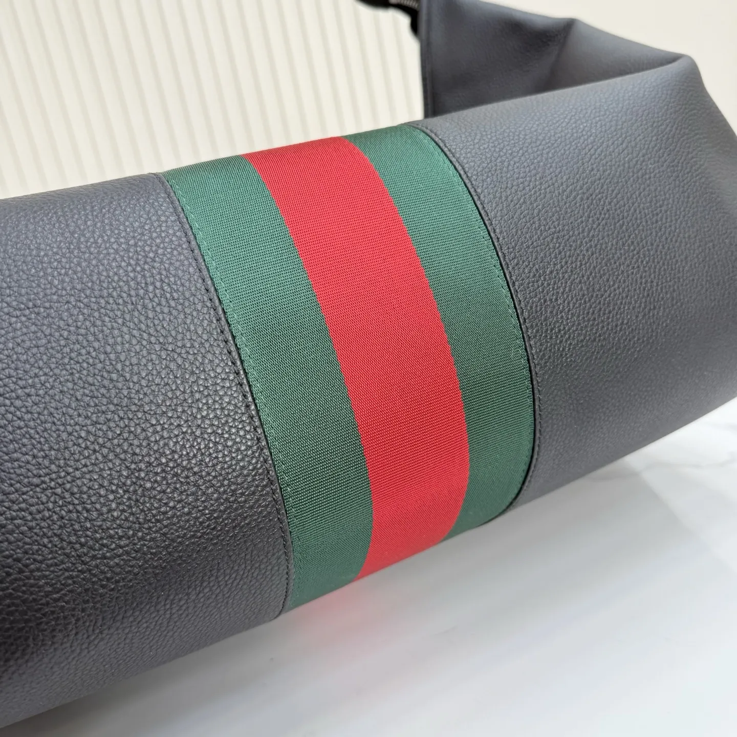 p800。【配全套包装】‼️Gucci Primavera系列通过融合创新与务实的愿景,确立了廓形、质地与材质的新语汇。加宽的织带嵌花细节以现代态度重塑包袋廓形。柔软的哑光皮革饰有低调的“Gucci Made in Italy”标识,多用途肩带适合日常出行背携。 黑色软皮,哑光表面 钯色金属配件 黑色针织衬里 织带嵌花和银色烫银“Gucci 意大利创作”标识 内部:1个拉链口袋 手柄垂直长度:30厘米 可拆卸和可调节皮革肩带,下垂长度65厘米,长度:100-120厘米 拉链开合 型号:A006KP。 尺寸:65厘米(宽)x20厘米(高)x37厘米(深) 重量:约1.430千克 颜色:黑色全皮。 意大利创作