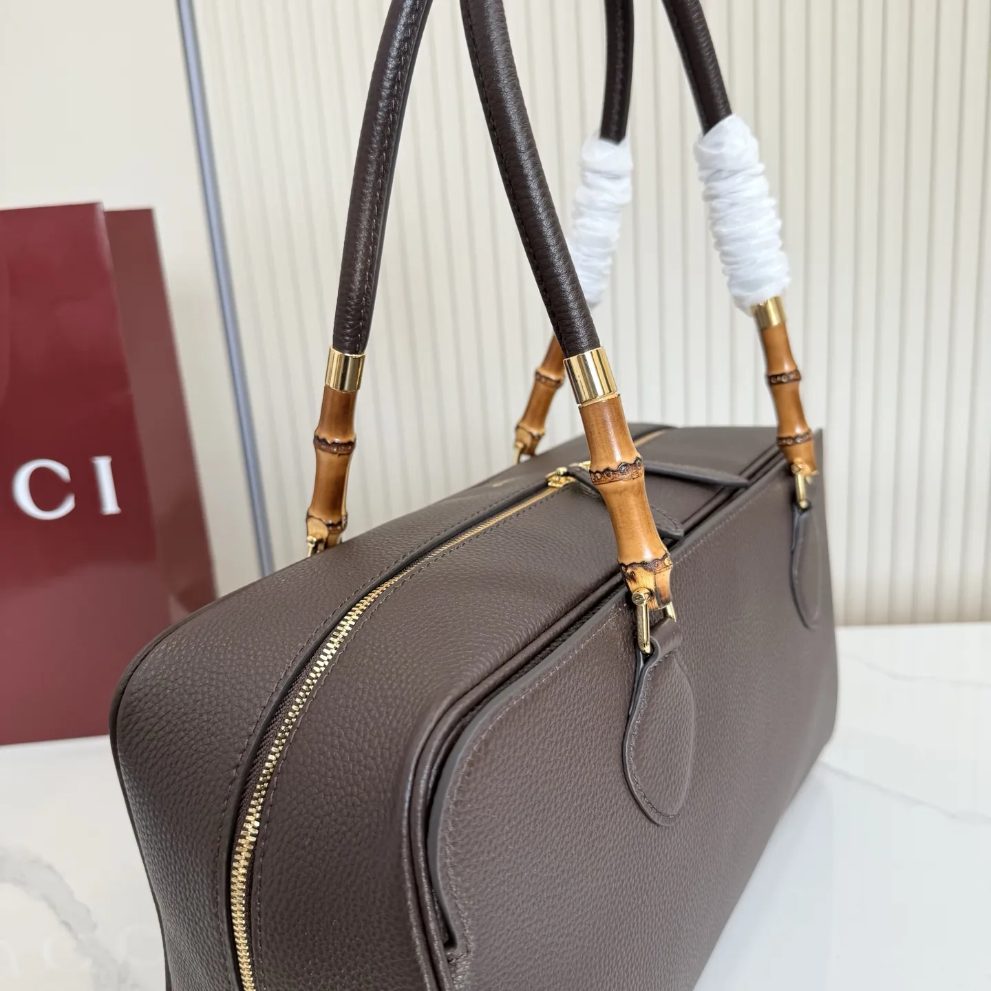 p820。【配全套包装】‼️Gucci Primavera系列通过融合创新与扎实的设计理念,为款式、质感和材质创造了全新语汇。这款多功能波士顿包设计中,品牌标志性的竹节元素以精致的点缀形式呈现,巧妙融入于精湛制作的皮革提手上,并配以金色调配件。 深棕色轻质皮革,半光泽表面 金色调配件 深棕色帆布衬里,饰钻石菱格纹图案 内部:1个拉链口袋 外部:1个开口口袋 手柄垂直高度:23厘米 双拉链封口 型号:A006OD。 尺寸:35.5厘米(宽)x 18厘米(高)x 14.5厘米(深) 重量:约1千克 颜色:深棕色/全皮。 意大利创作