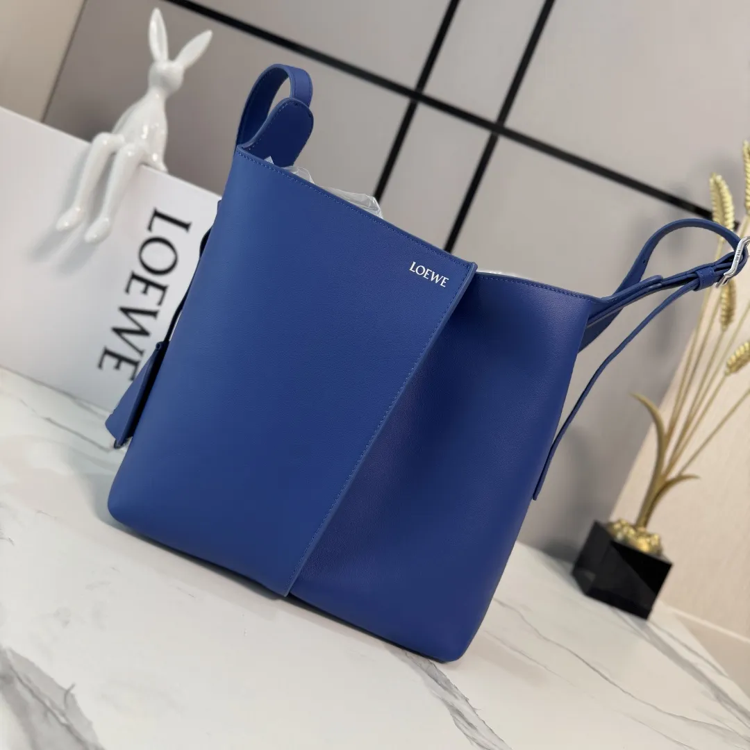 LO℮w℮🌟中号光滑Bilbao梯形水桶包 呈现简约几何设计。采用皮革拼接打造,中央饰有褶皱,造型柔软贴身,是日常随身携带的理想选择。此中号版本采用光滑牛皮革制成。*🉑肩背或斜挎*🉑调节肩带*🉑拆卸Double L压纹皮革钟形挂饰,内藏实用开瓶器*额外的外部D形环,可用于搭配个性化挂饰*钩扣🉑固定随身物品 绒面革衬里*LOE*WE烫银. size:13*25*24CM 型号:652604 F:780