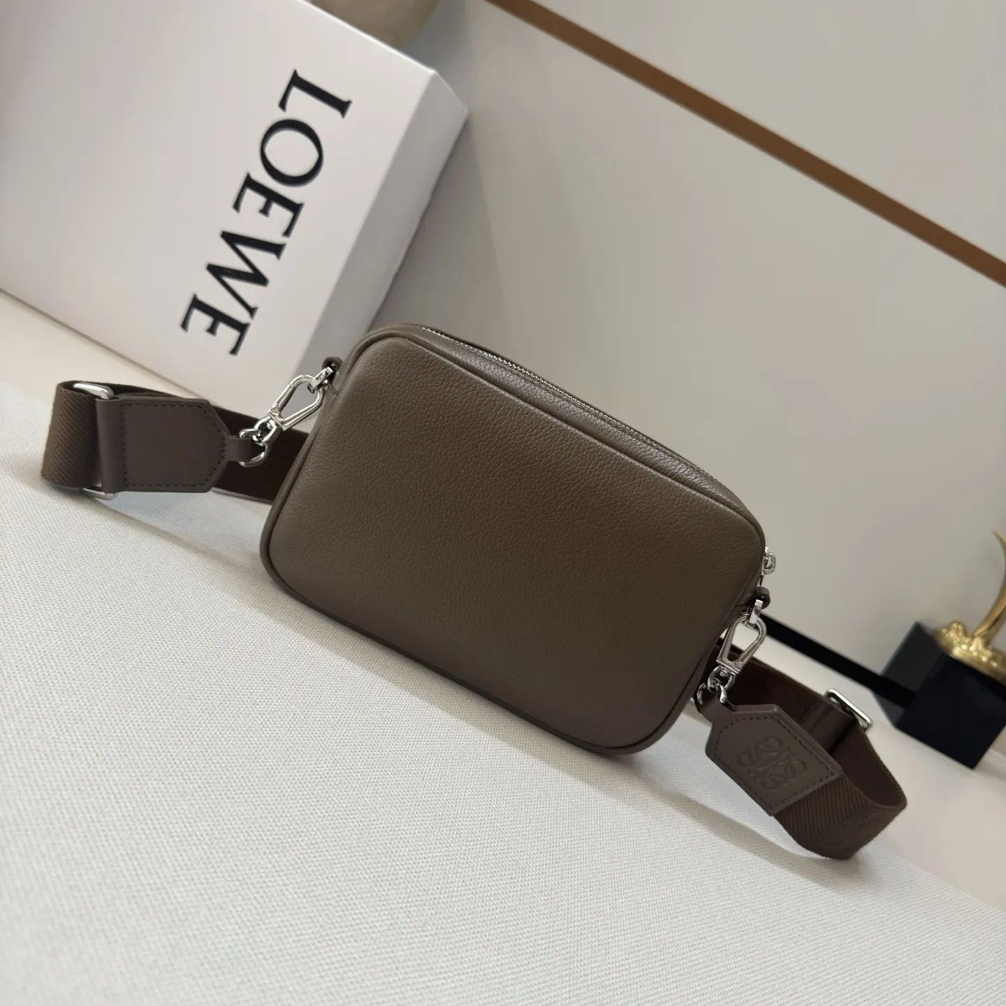 LO℮w℮🌟新款小号柔软粒面牛皮革Pebble邮差包.采用实用精巧设计.配有双重标志性是Anagram Pebble.此版本采用柔软粒面牛皮革制成。可调节LO℮w℮织带*拉链开合*一个磁扣开合正面口袋、一个内部插袋 绒面革衬里LO℮w℮烫银，Anagram Pebble. size：20*6*12.5 型号：652514 F680（配全套包装）