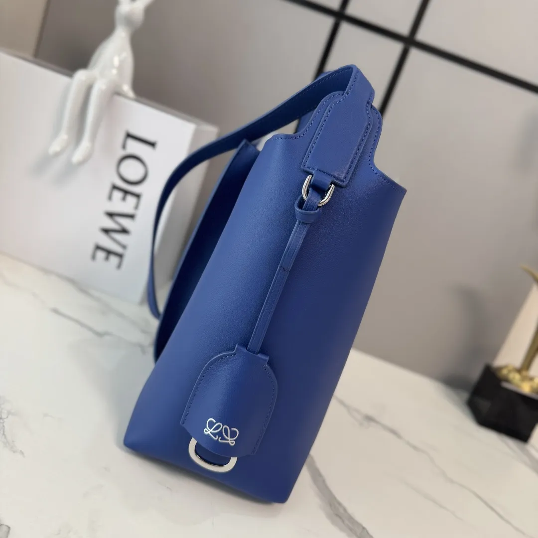 LO℮w℮🌟中号光滑Bilbao梯形水桶包 呈现简约几何设计。采用皮革拼接打造,中央饰有褶皱,造型柔软贴身,是日常随身携带的理想选择。此中号版本采用光滑牛皮革制成。*🉑肩背或斜挎*🉑调节肩带*🉑拆卸Double L压纹皮革钟形挂饰,内藏实用开瓶器*额外的外部D形环,可用于搭配个性化挂饰*钩扣🉑固定随身物品 绒面革衬里*LOE*WE烫银. size:13*25*24CM 型号:652604 F:780