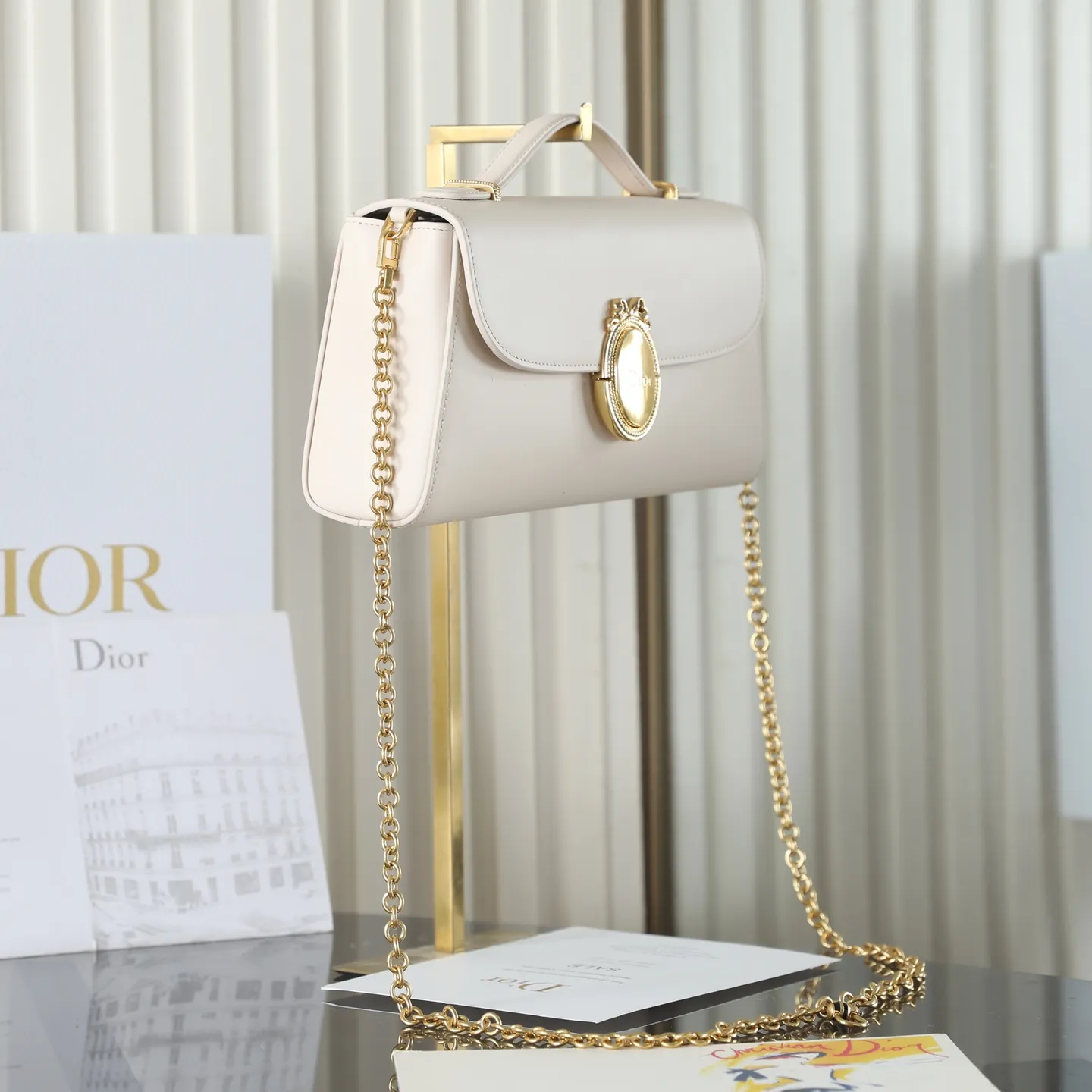 P700 原厂级 Médaillon 手拿包\n\n这款 Dior Médaillon 手拿包设计百搭,彰显 Dior 经久不衰的优雅风范。Dior Médaillon 标志扣环呼应 Dior 沙龙 18 世纪洛可可风格的优雅格调,缝有三角形衬料的挺括廓形则突显时髦气息。设有顶部手柄和可调节、可拆卸的链条,可手提或肩背突显高雅气质,可与日常造型或晚装搭配。\n\nM3671\n尺寸:26 x 11.5 x 4.5 厘米(长 x 高 x 宽)