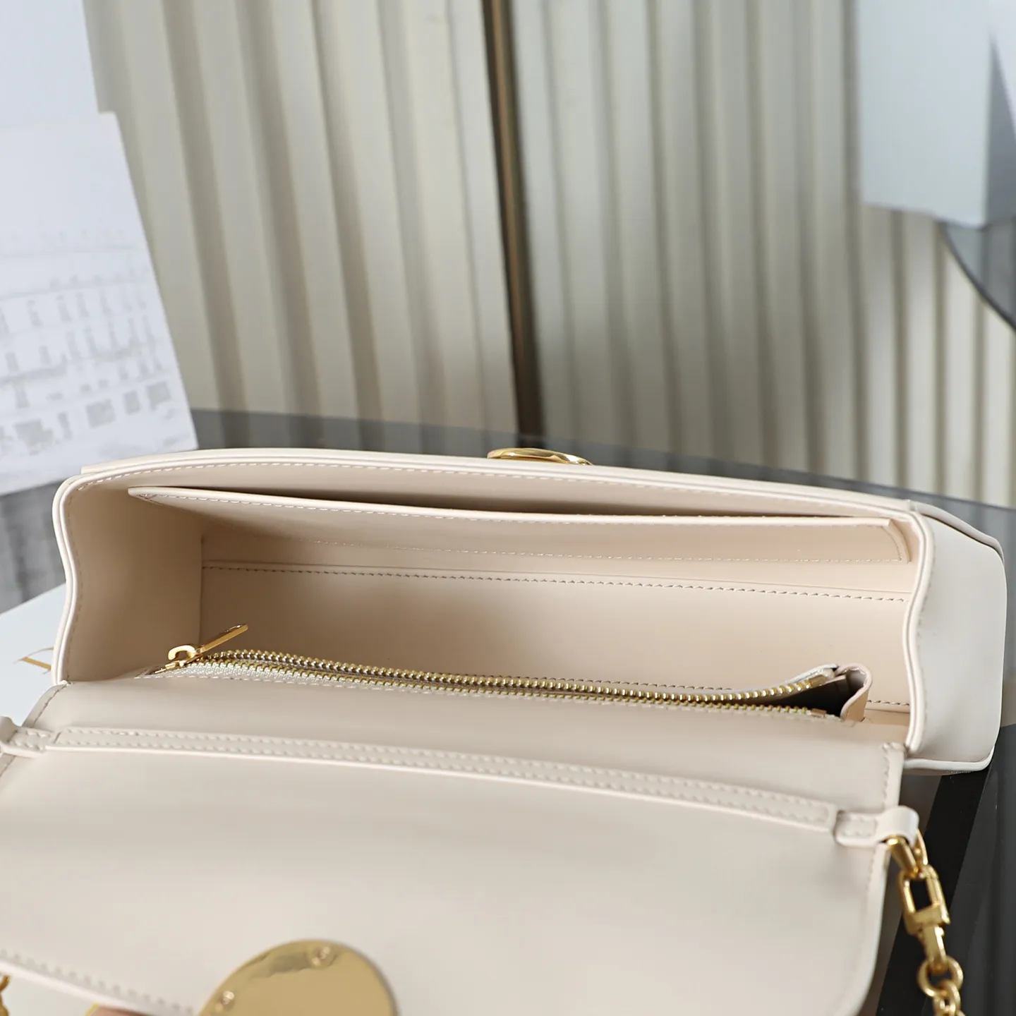 P700 原厂级 M&eacute;daillon 手拿包\n\n这款 Dior M&eacute;daillon 手拿包设计百搭，彰显 Dior 经久不衰的优雅风范。Dior M&eacute;daillon 标志扣环呼应 Dior 沙龙 18 世纪洛可可风格的优雅格调，缝有三角形衬料的挺括廓形则突显时髦气息。设有顶部手柄和可调节、可拆卸的链条，可手提或肩背突显高雅气质，可与日常造型或晚装搭配。\n\nM3671\n尺寸：26 x 11.5 x 4.5 厘米（长 x 高 x 宽）